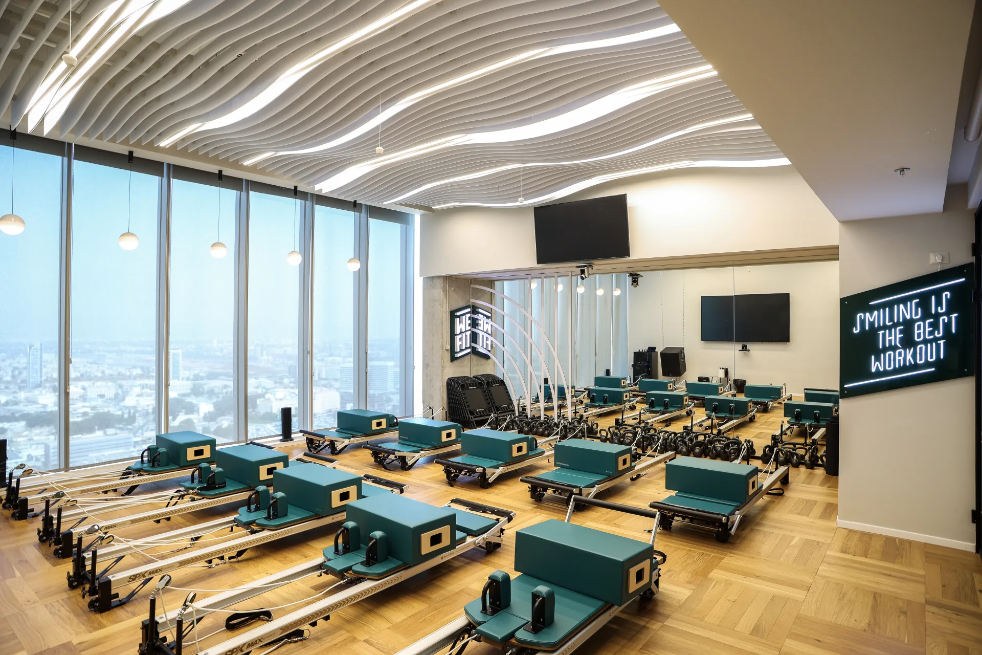 Pilates studio with a wavy illuminated ceiling and city view