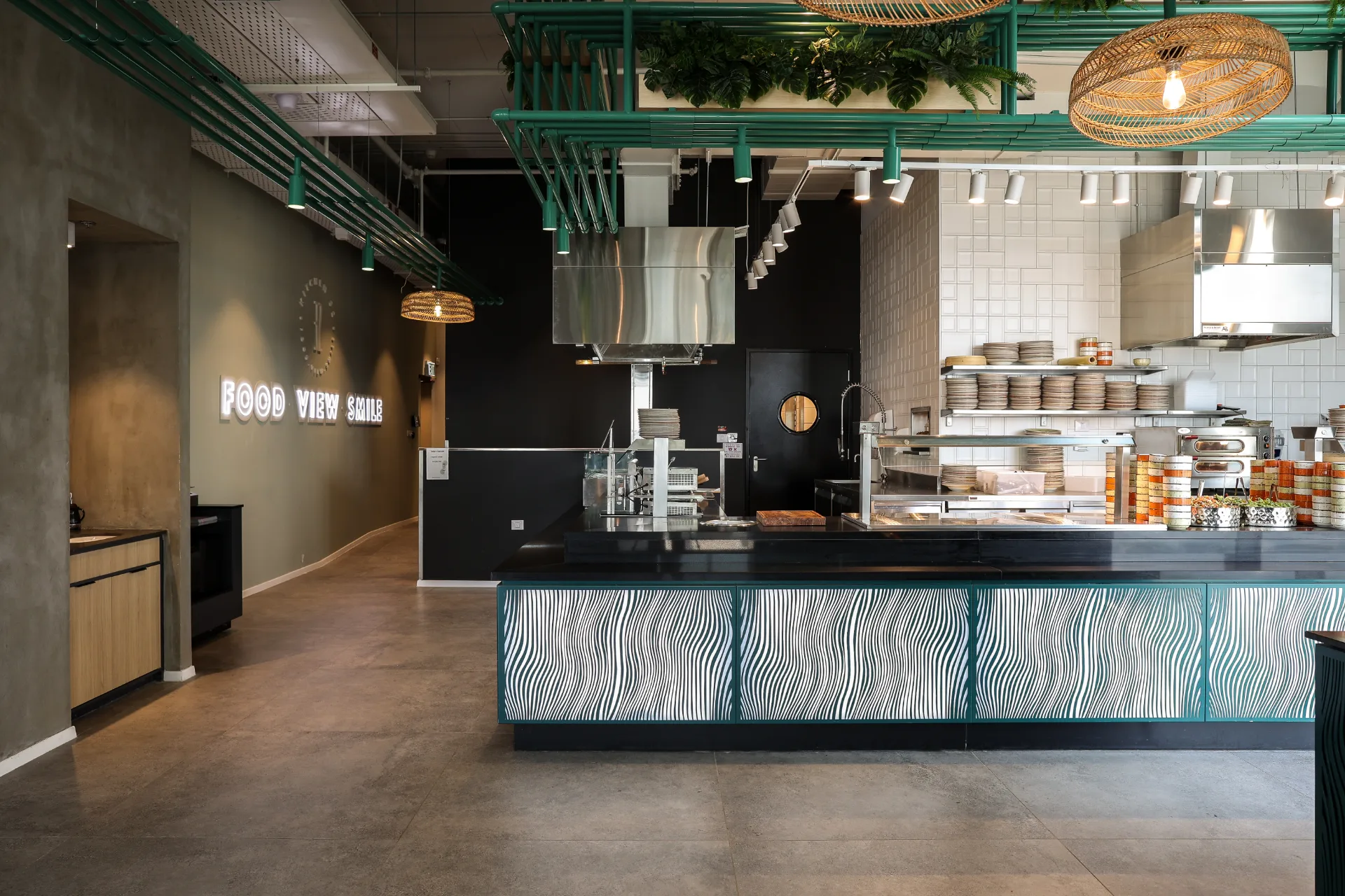Staff cafeteria with an open kitchen and pendant lighting