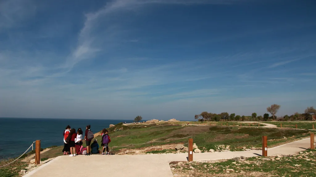 Visitors at a cliff-top viewpoint over the sea