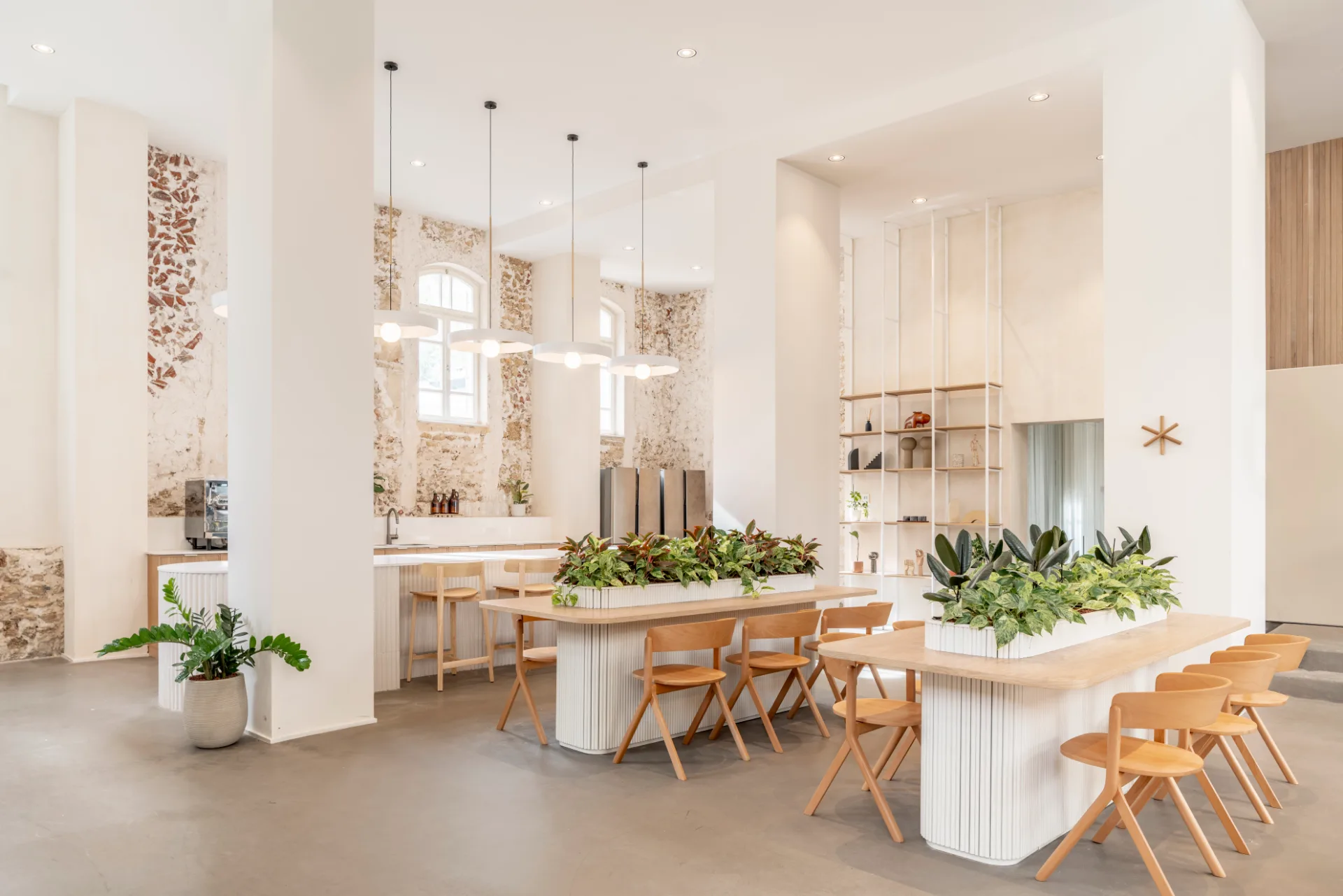 Cafe tables with planting beside a brick wall