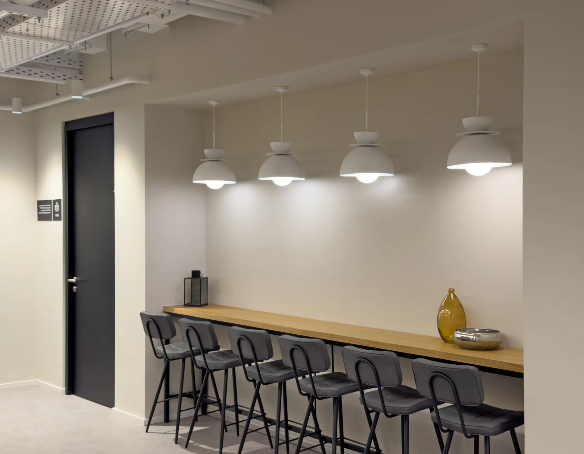 High counter beneath a row of pendant fixtures