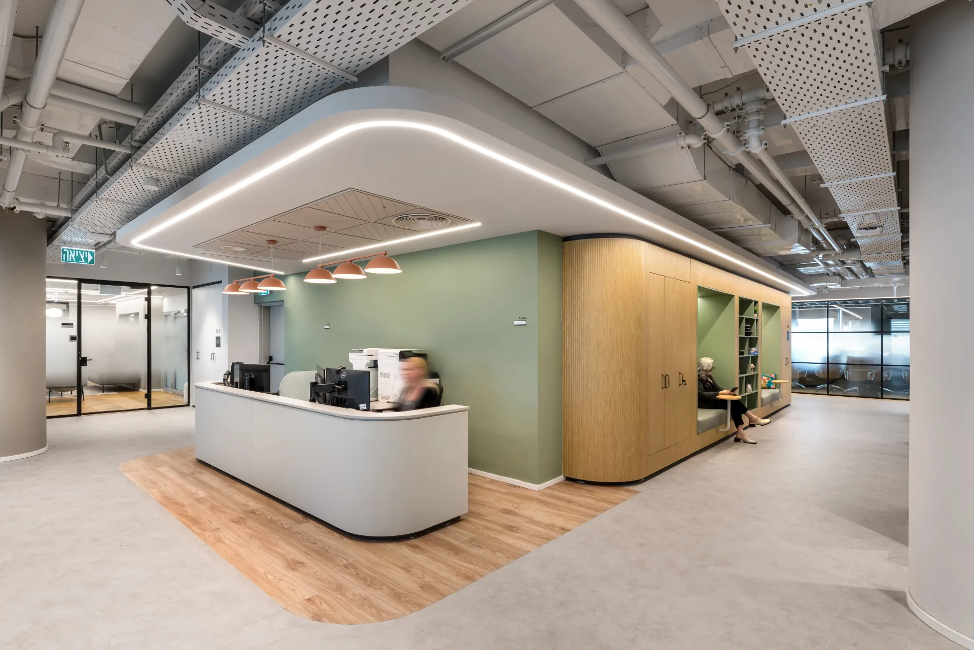 Reception desk against a green wall with pendant fixtures
