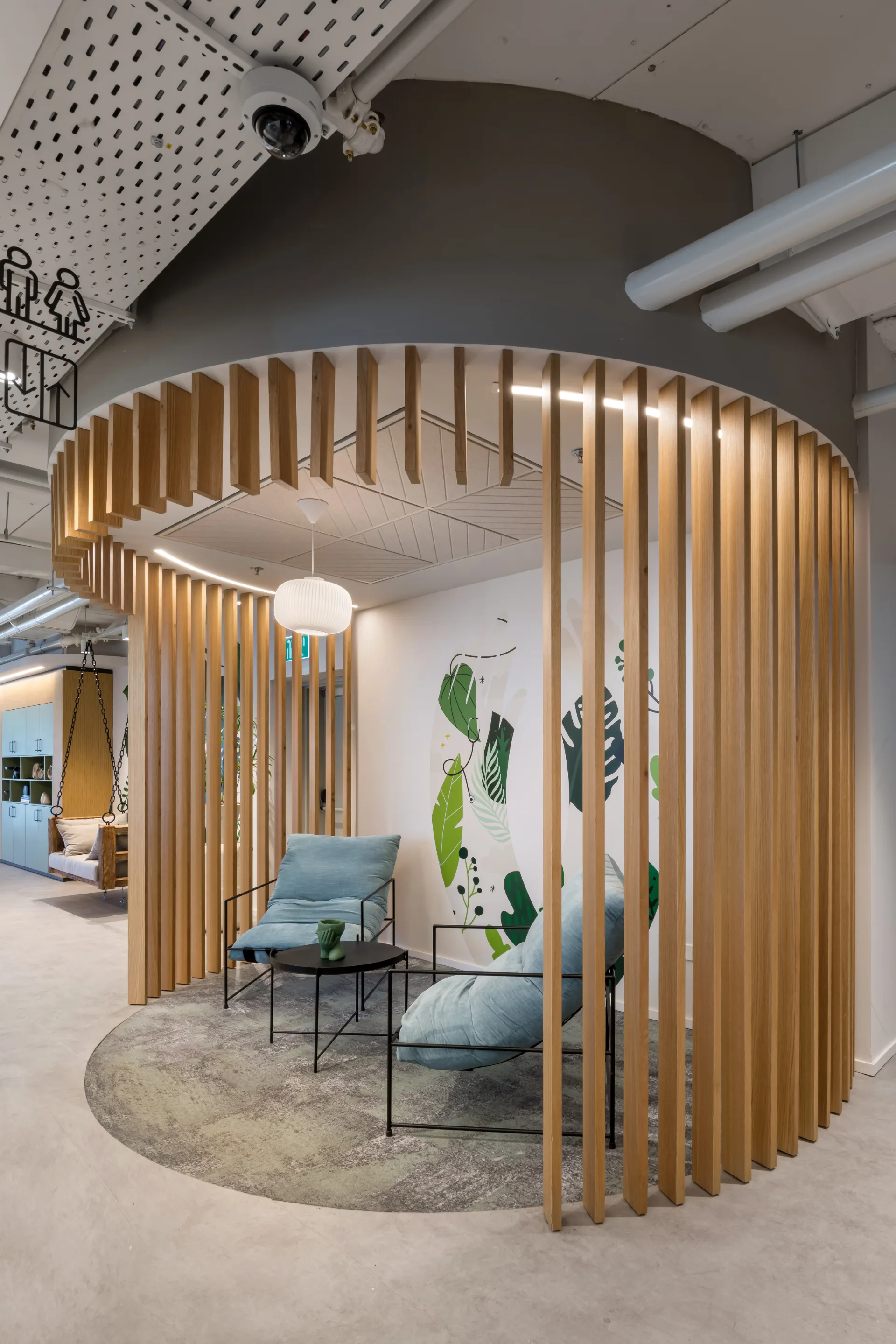 Seating nook within a circular timber-slat enclosure