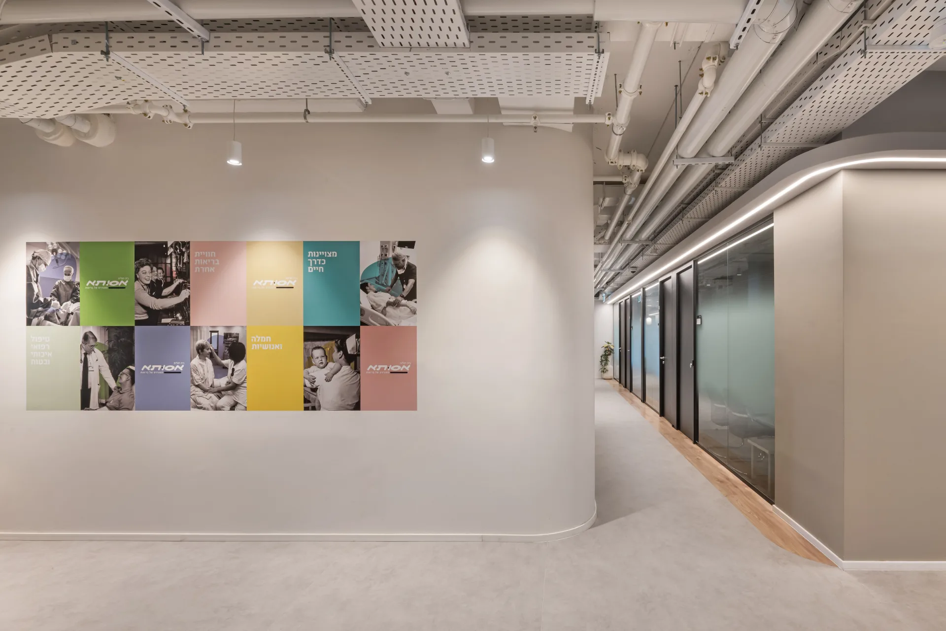 Assuta graphic wall beside a corridor of glazed rooms