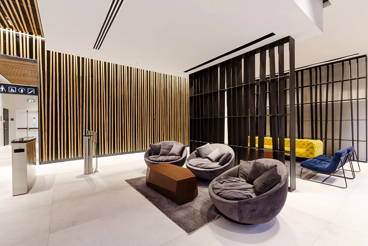 Lounge seating along the backlit timber wall