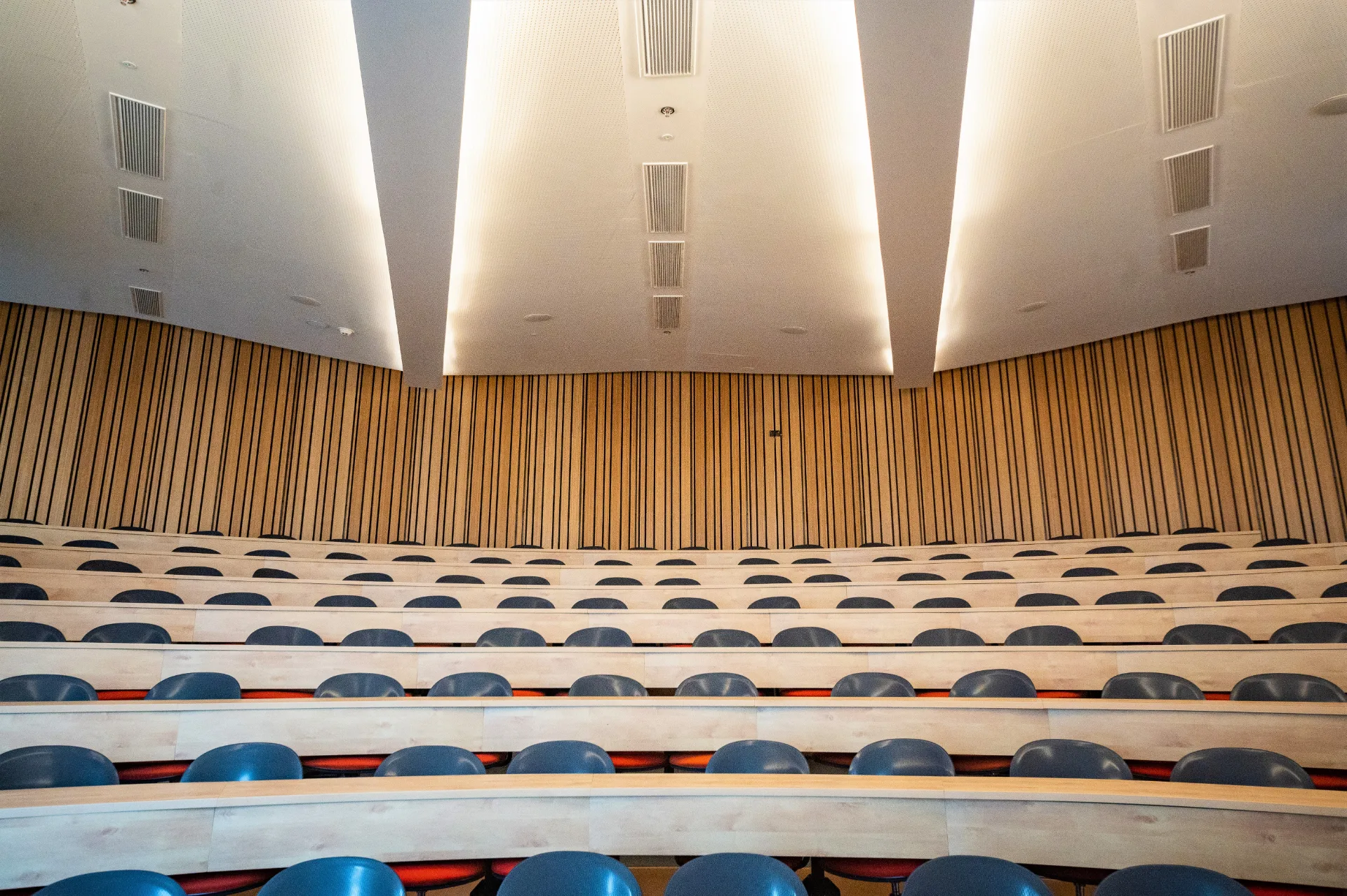 Auditorium beneath a backlit sculpted ceiling