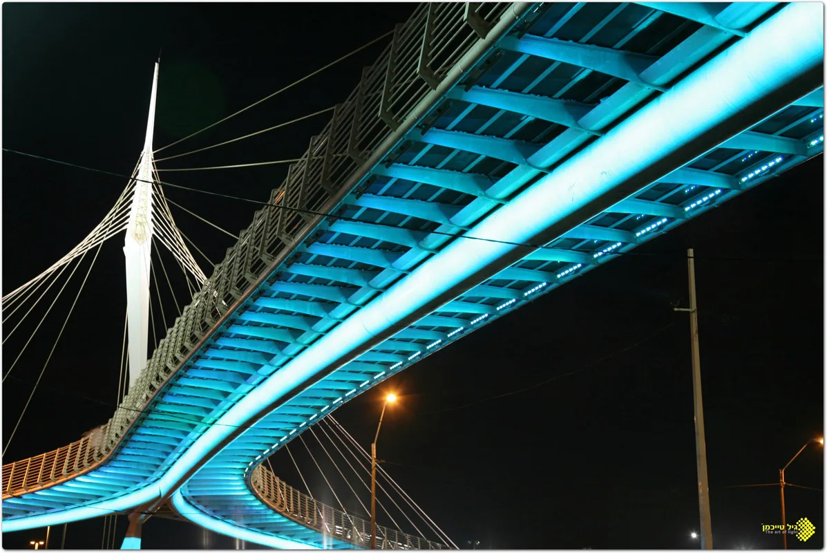 The cyan-lit underside of the curving bridge
