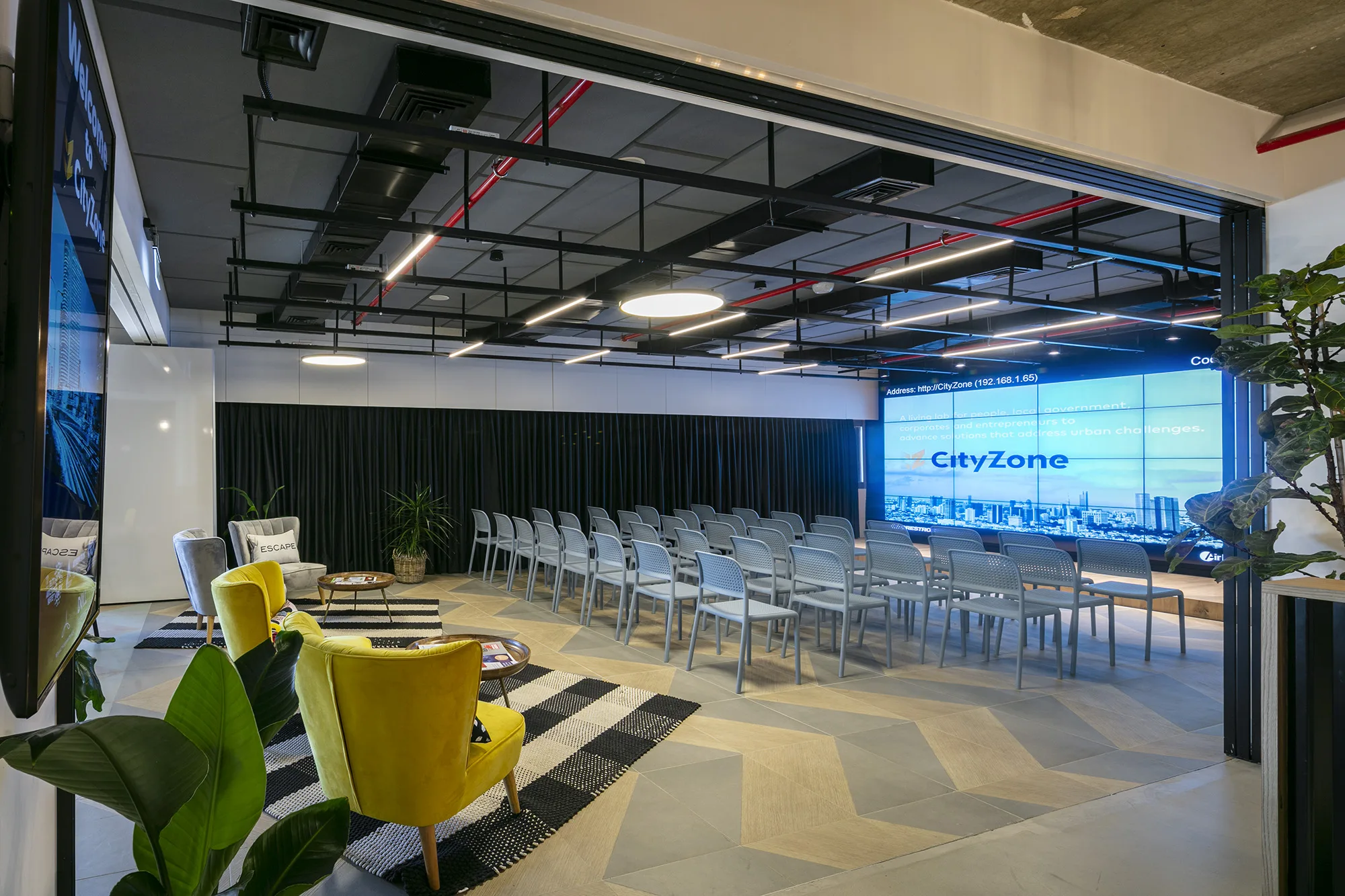 The event hall with the CityZone screen and yellow armchairs