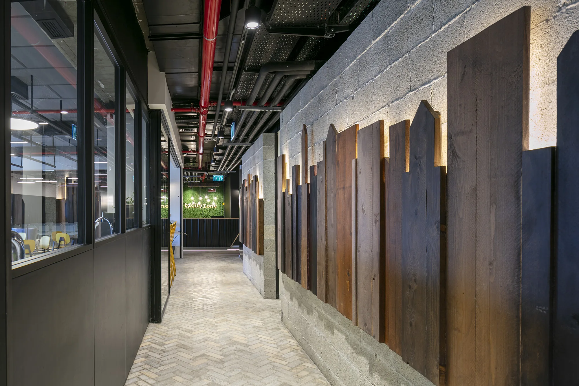A corridor lined with grazed timber boards on raw concrete