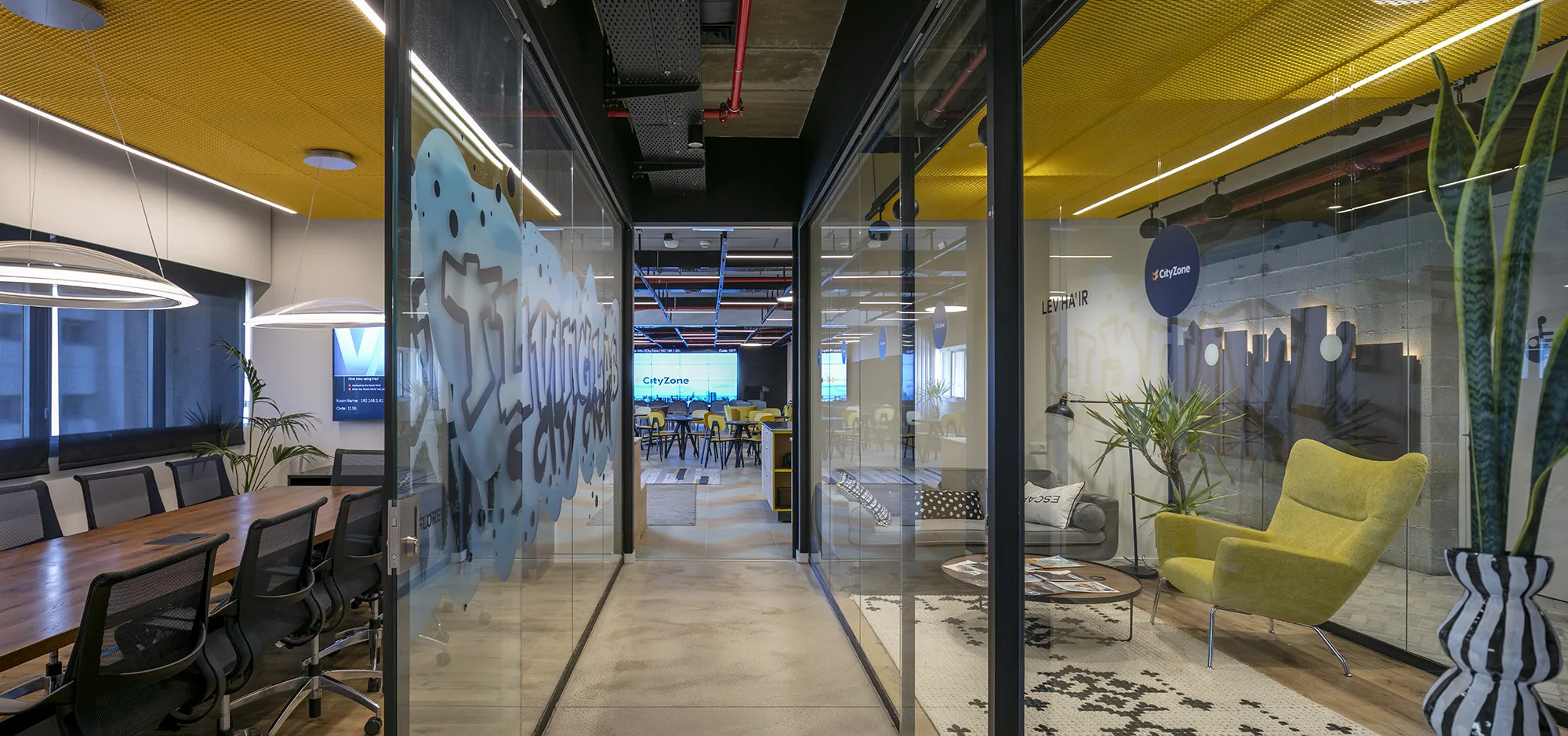 A glazed meeting room and corridor with graffiti-art glass