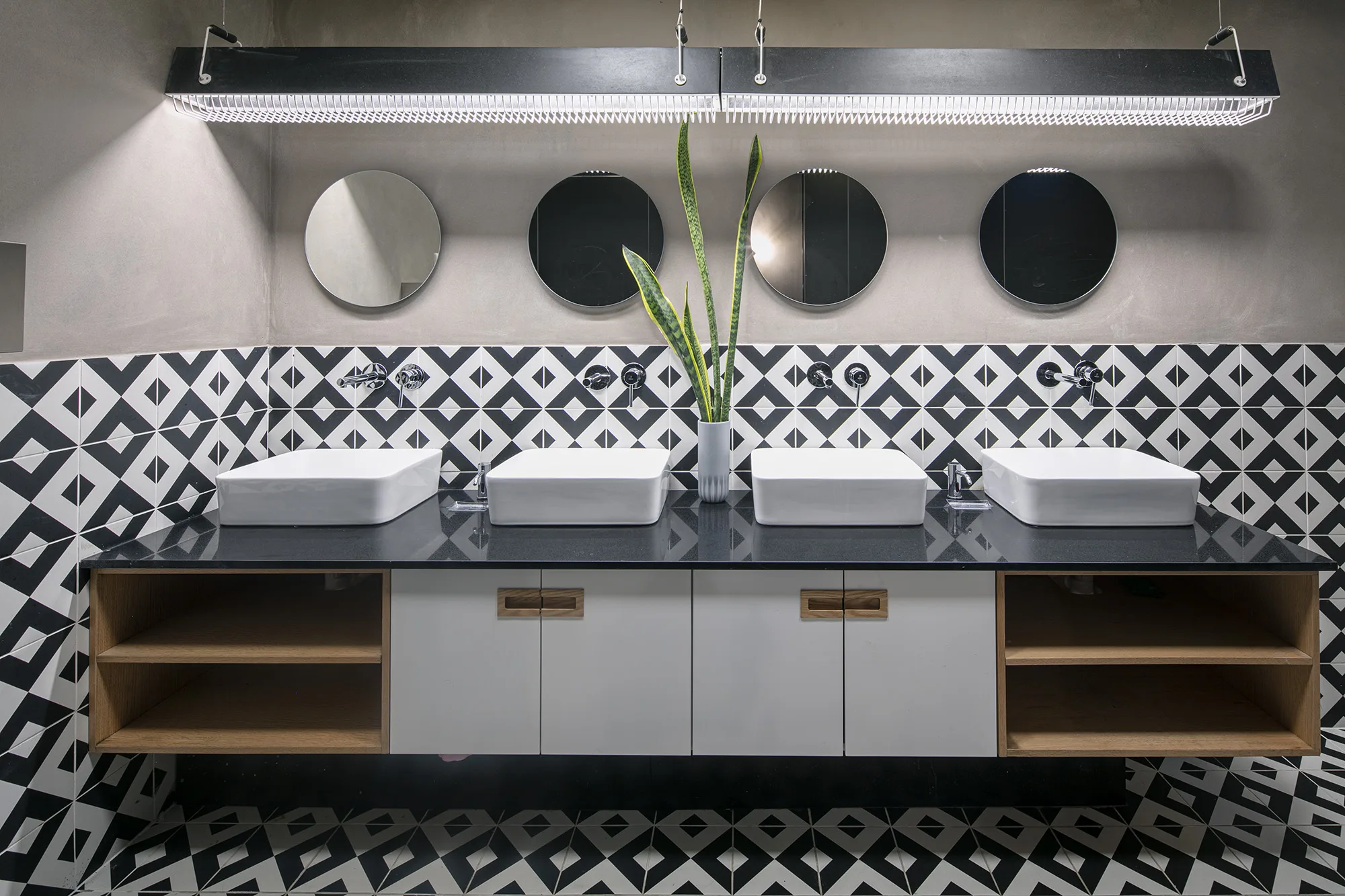 The restroom vanity under a beaded linear light fixture