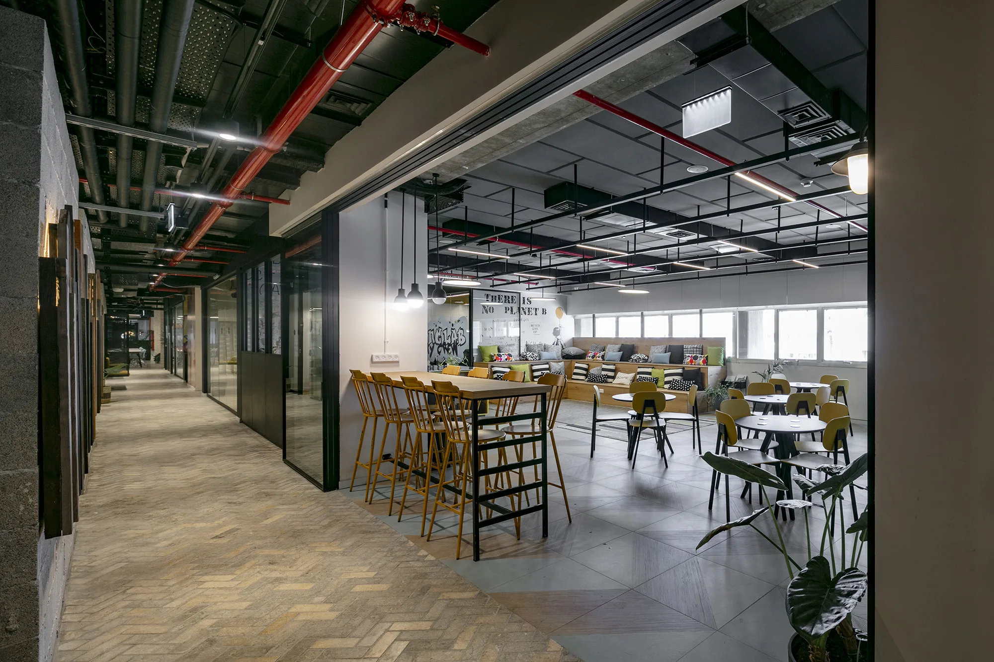 A café lounge with high tables and a 'no planet B' mural