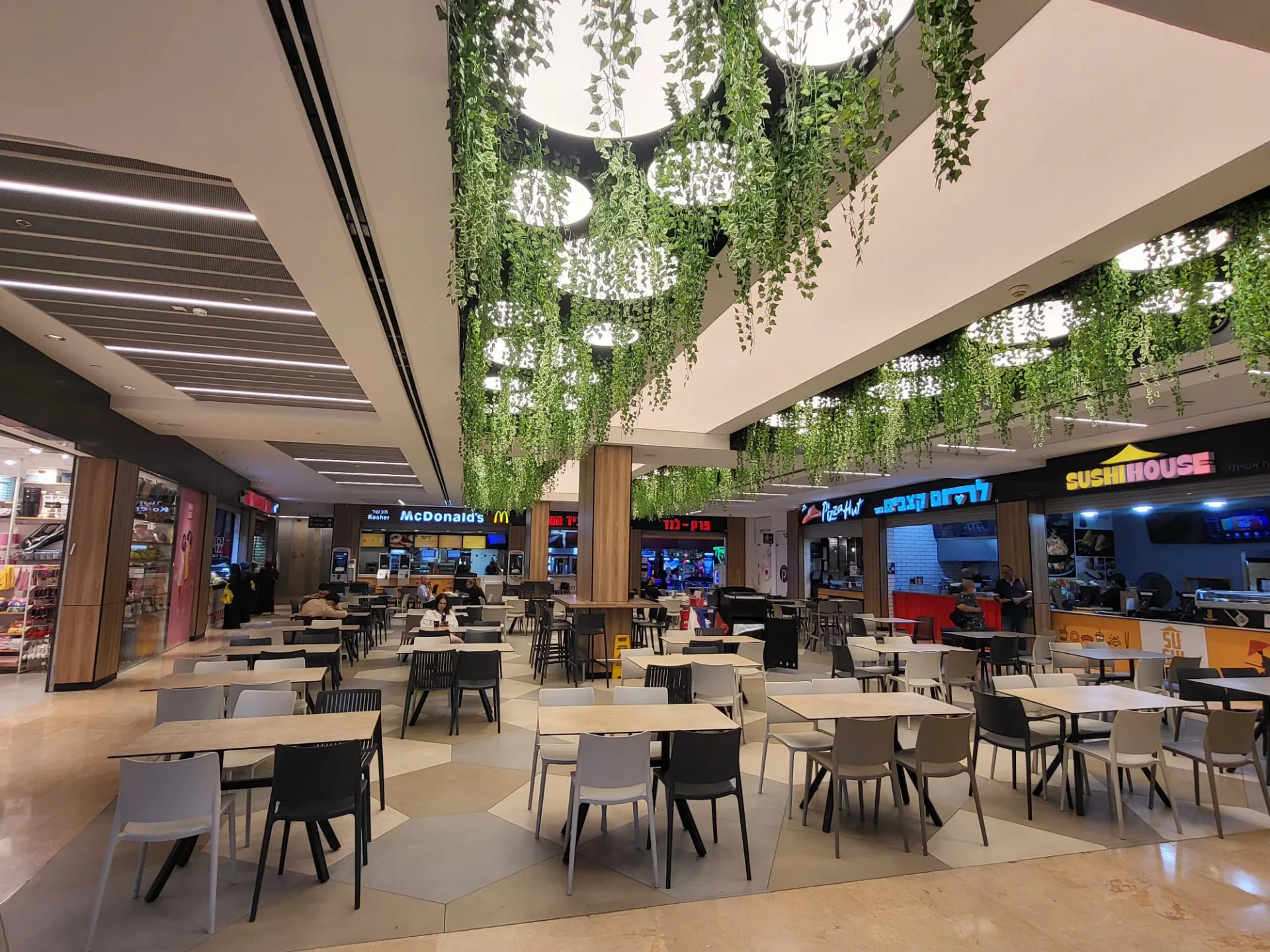 Food court with hanging greenery and soft lighting