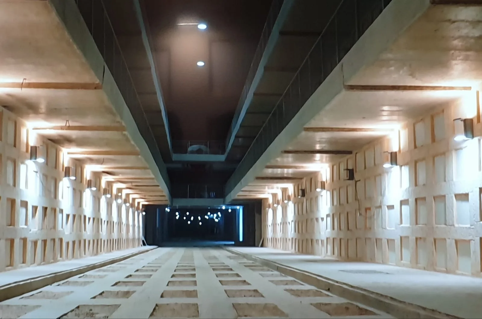 Illuminated underground corridor at Har HaMenuchot