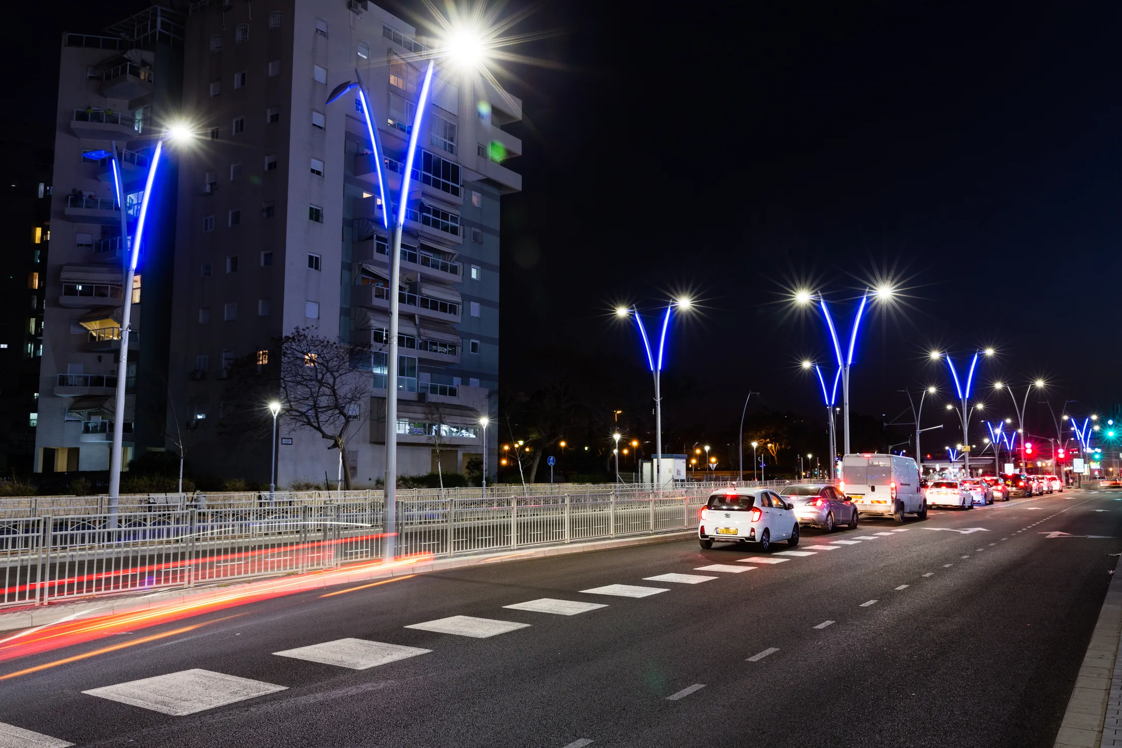 Lighting poles with blue LED strips beside residential buildings