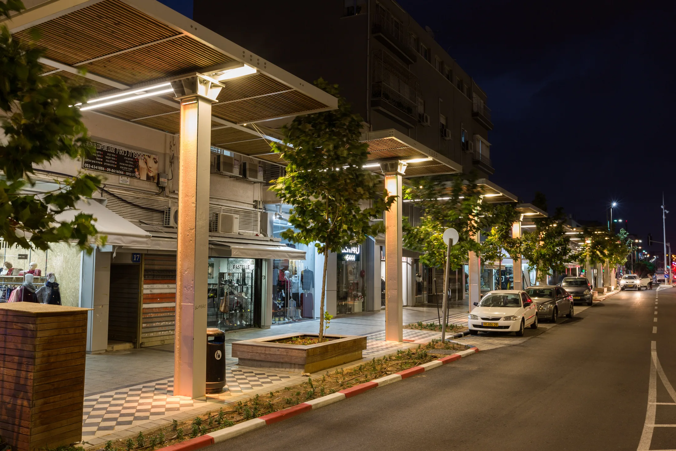 A promenade and plaza with pedestrians and colorful lighting