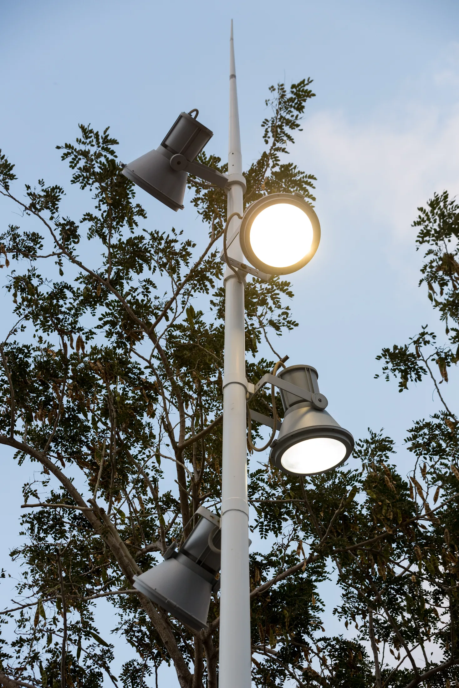 A luminaire at the top of a pole against the sky