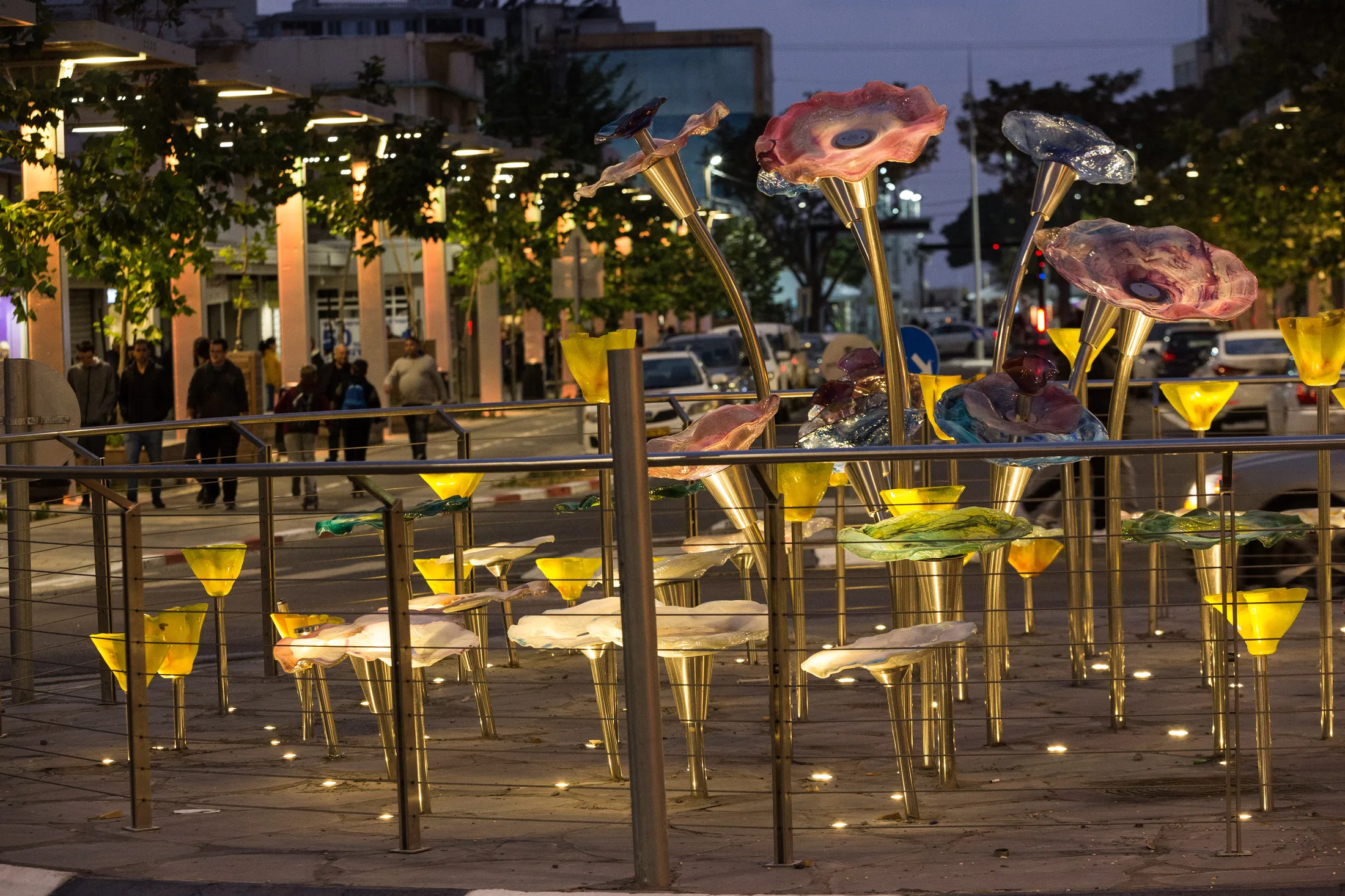 A sculptural light installation of colorful flowers lit along the promenade