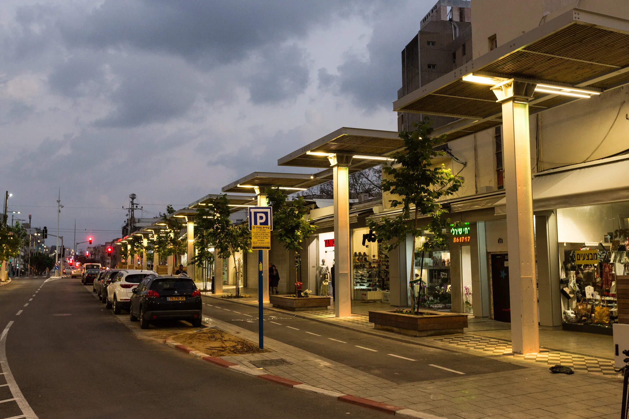 The street colonnade lit warmly above the shopfronts