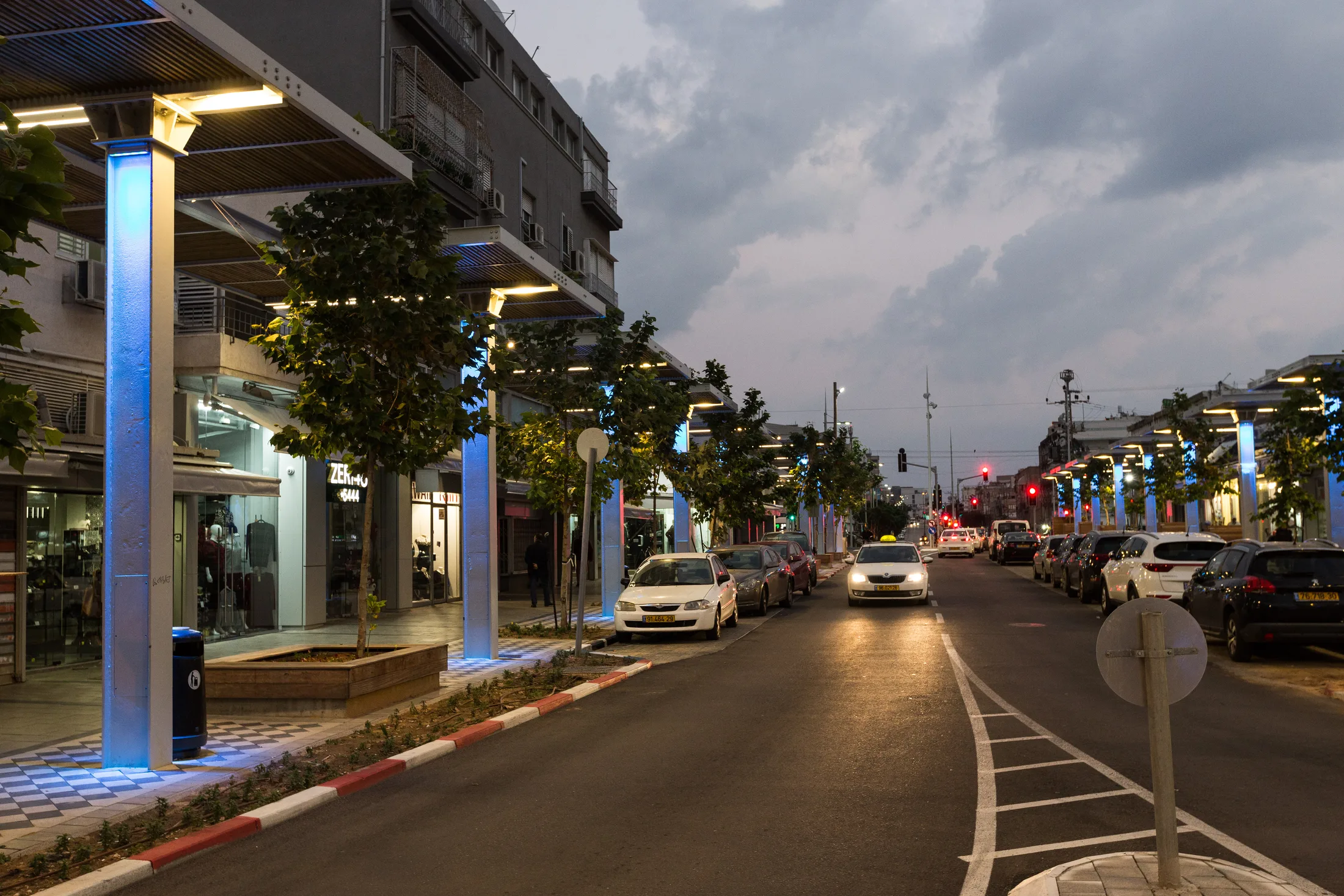 A wide view of the street at dusk with colorful accent lighting
