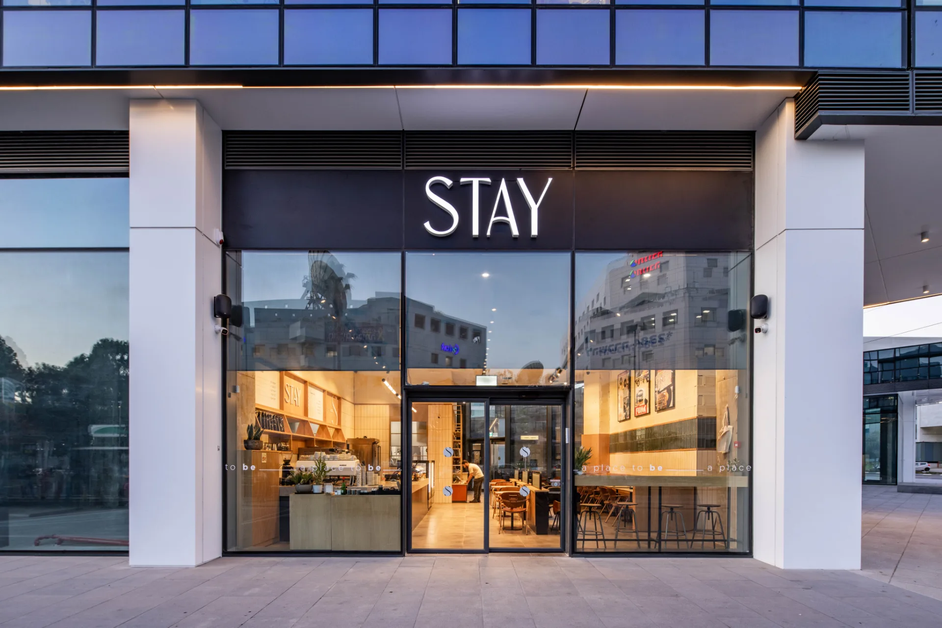 Illuminated retail storefront at the complex at dusk