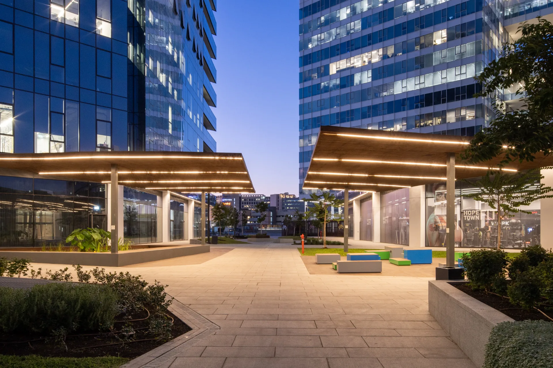 Lit pergola promenade through the landscaped plaza