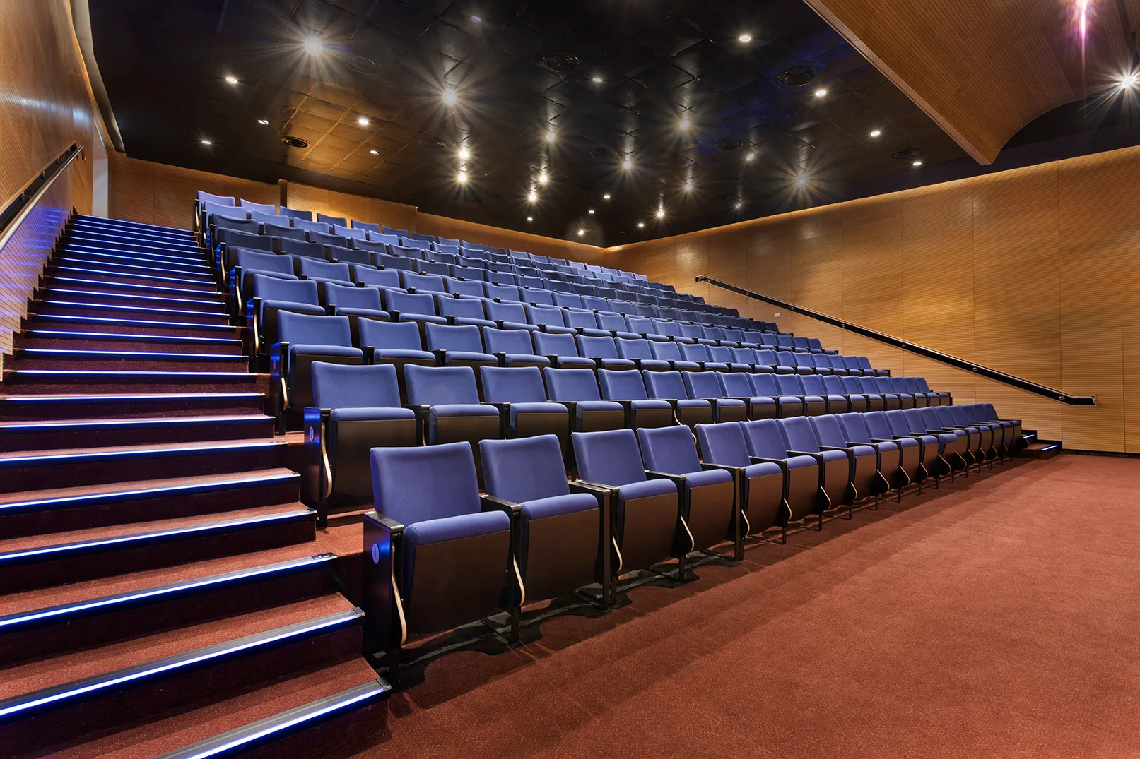 Auditorium with warm downlights and lit stairs