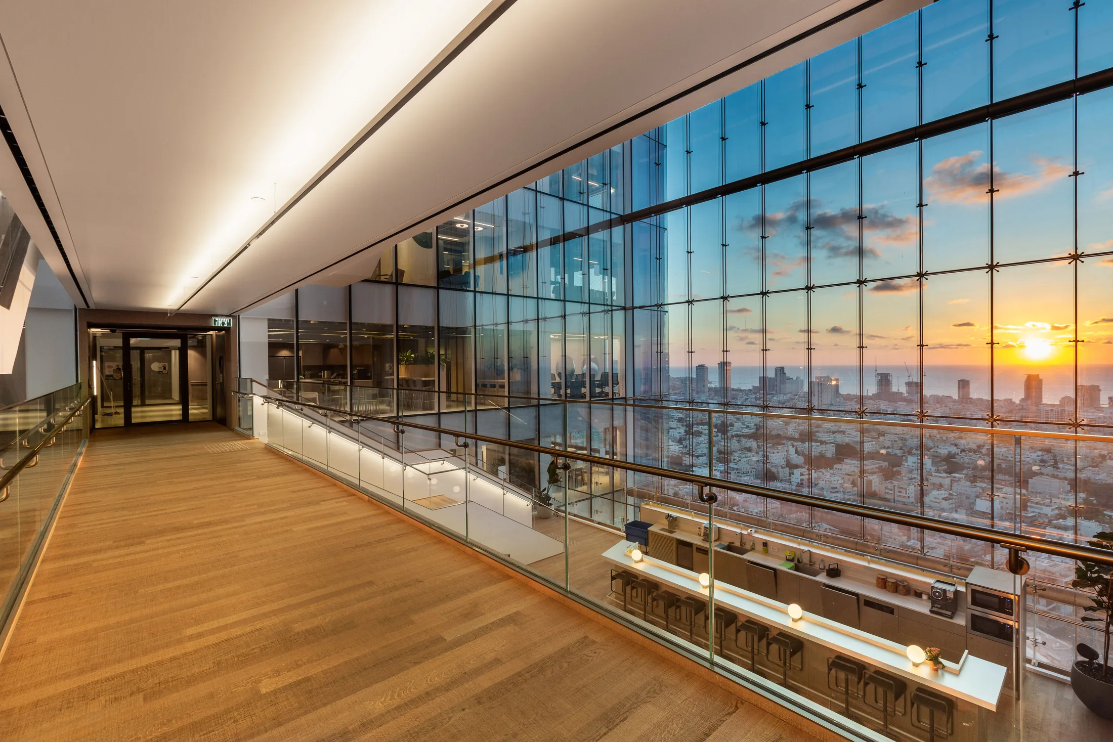 A high terrace with a wood deck and a city view at sunset