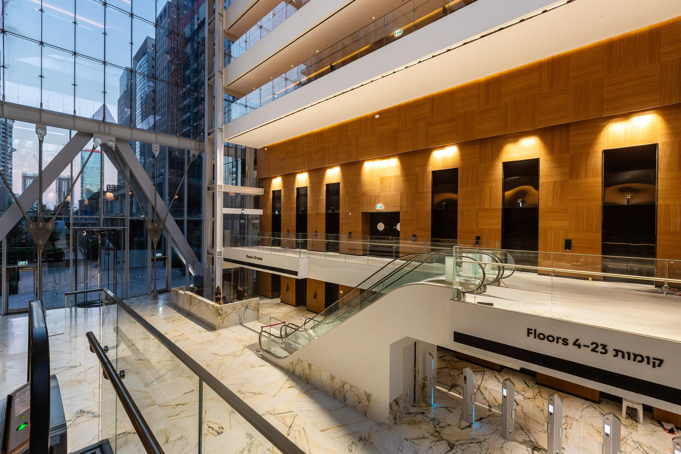 The double-height main lobby clad in wood with warm cove lighting
