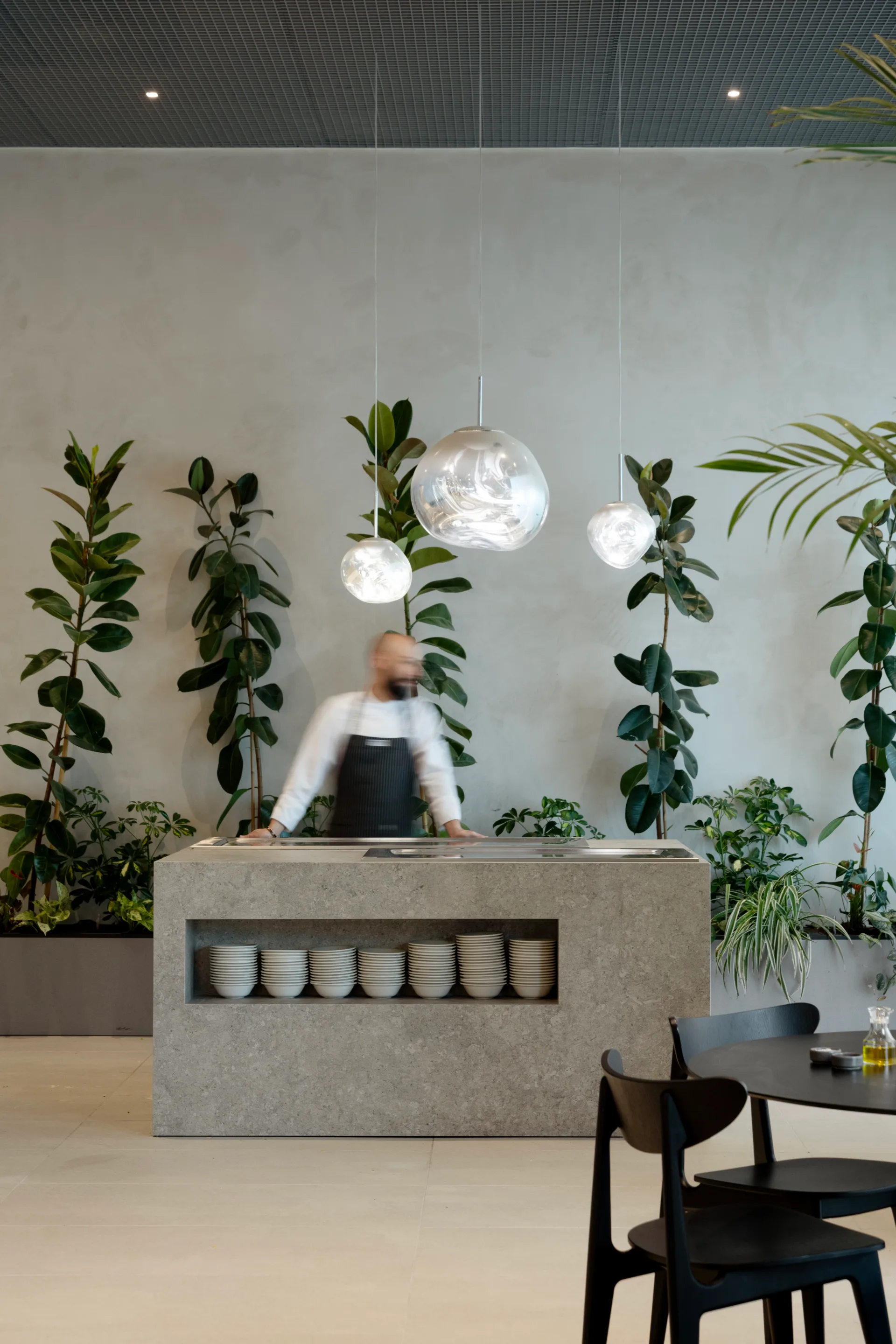 Coffee bar with sculptural glass pendants and plants
