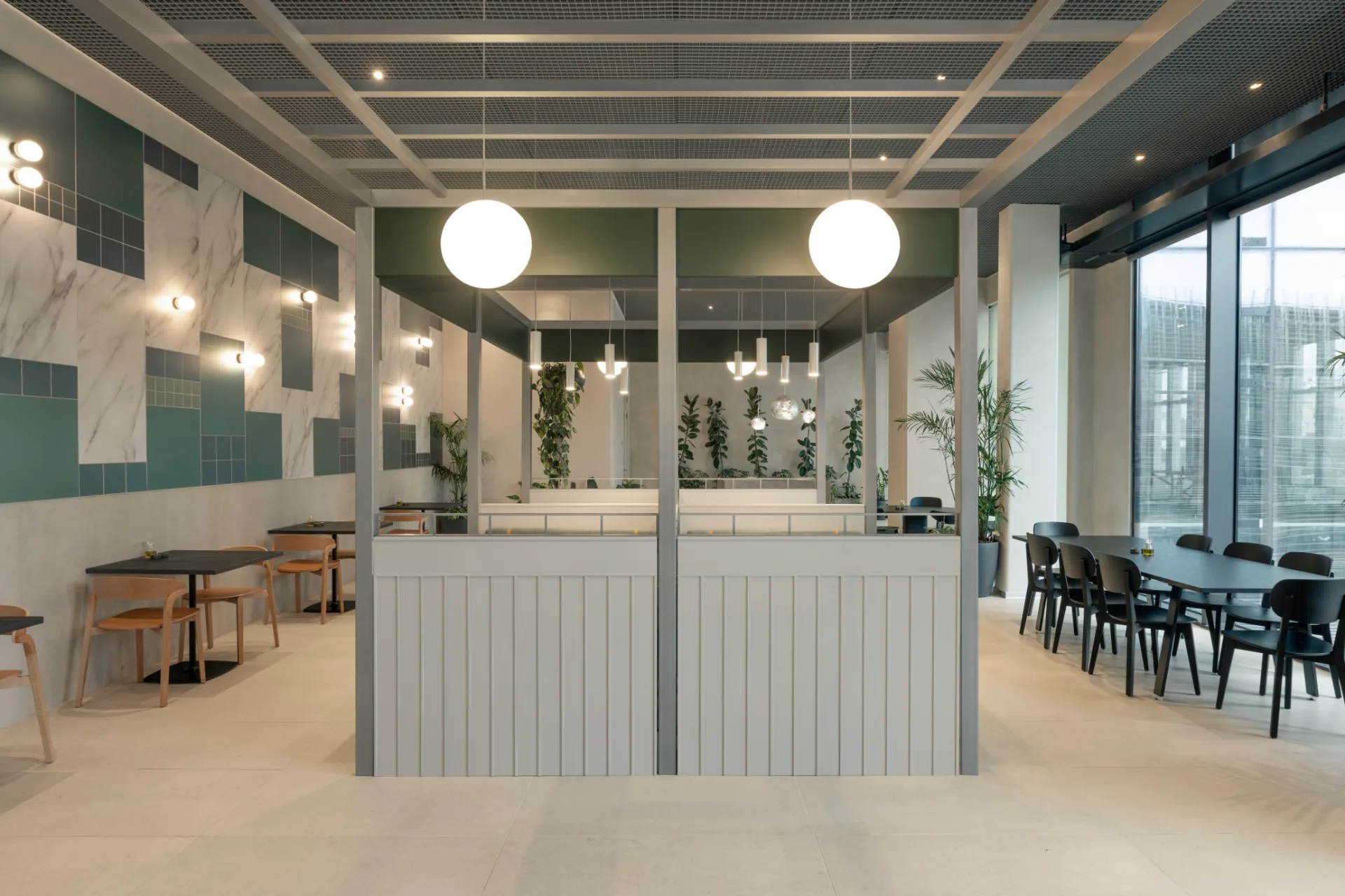 Café with globe pendants and a marble-and-green wall