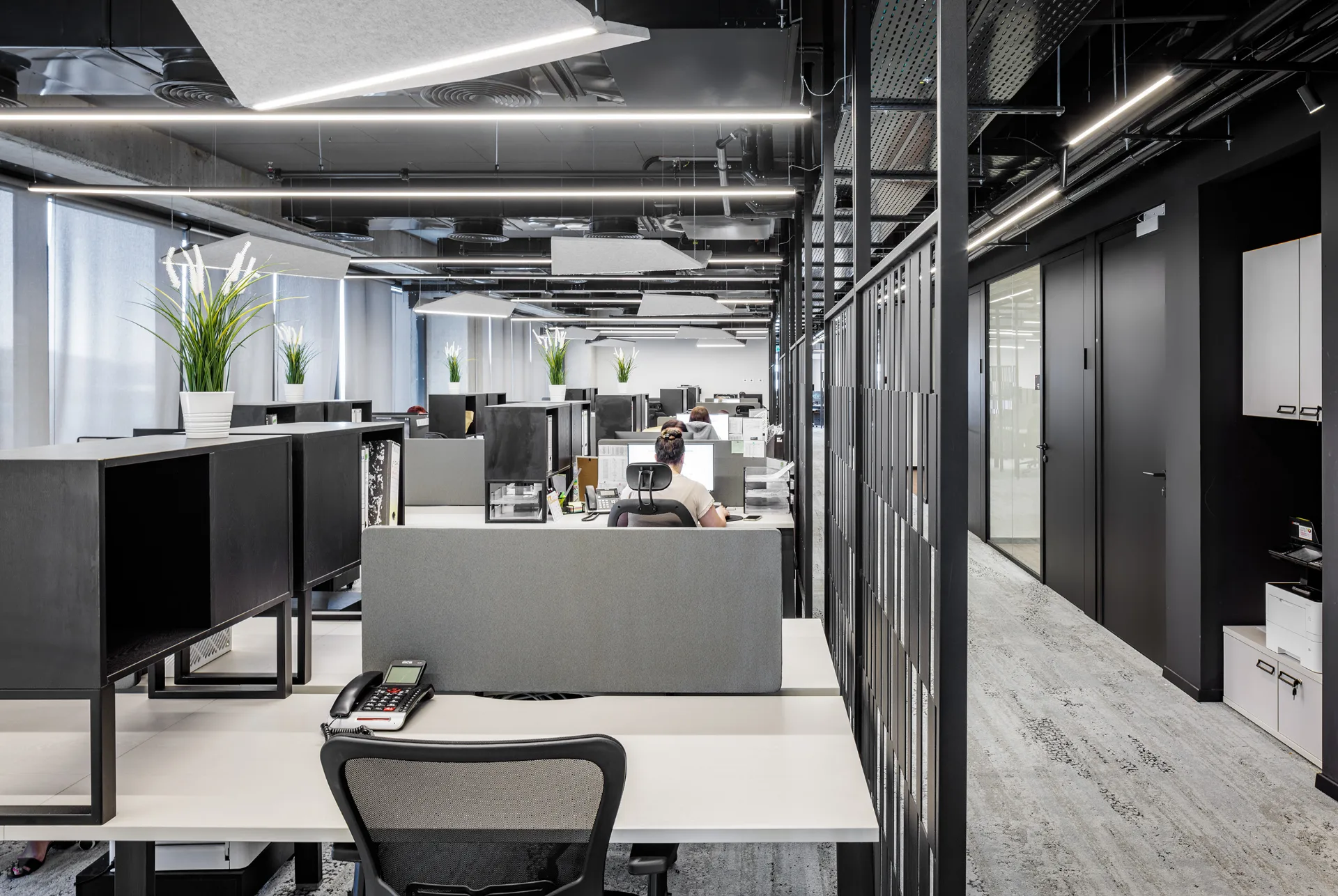 Open work area beneath the exposed black ceiling