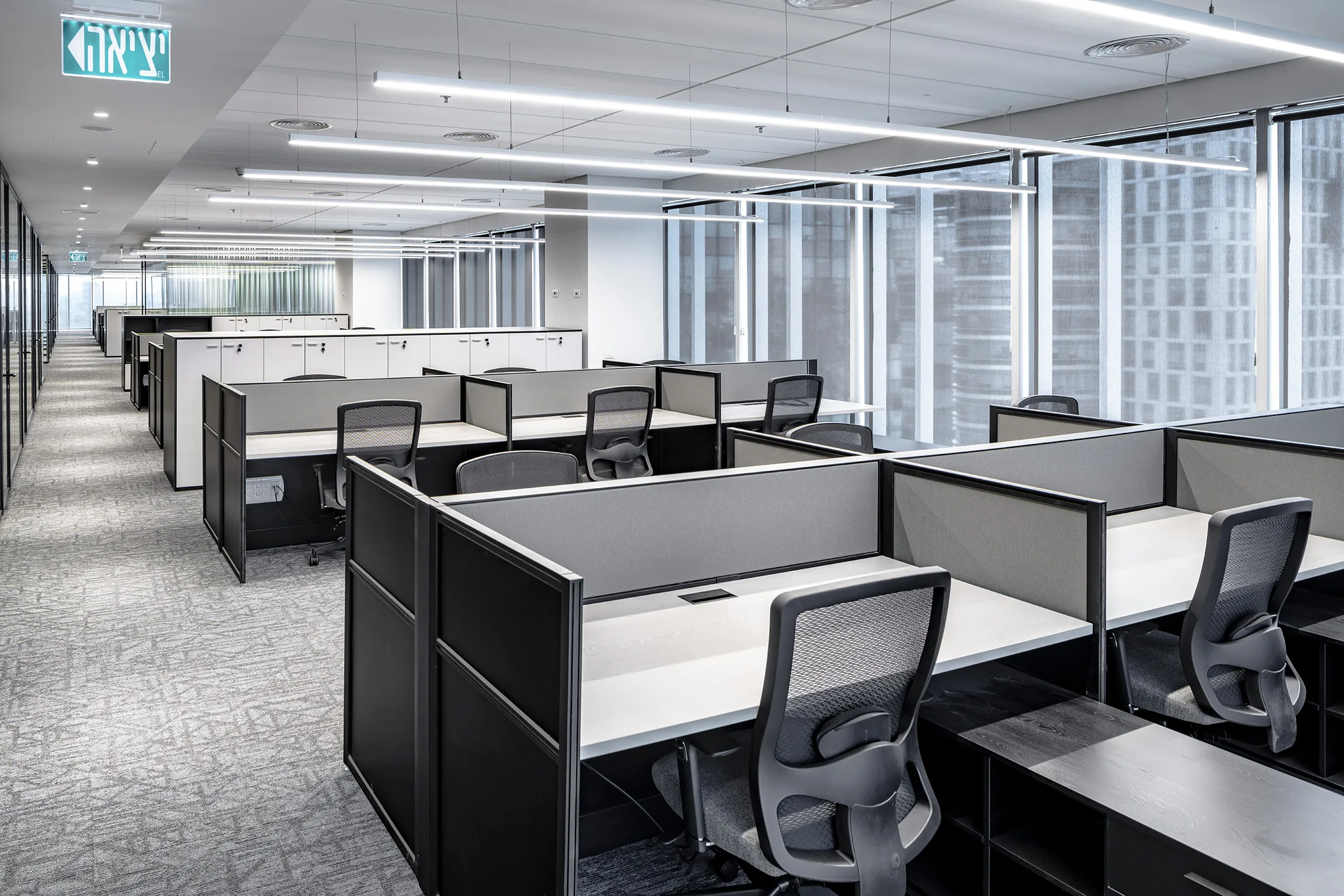An open-plan workspace with linear light lines and panoramic windows
