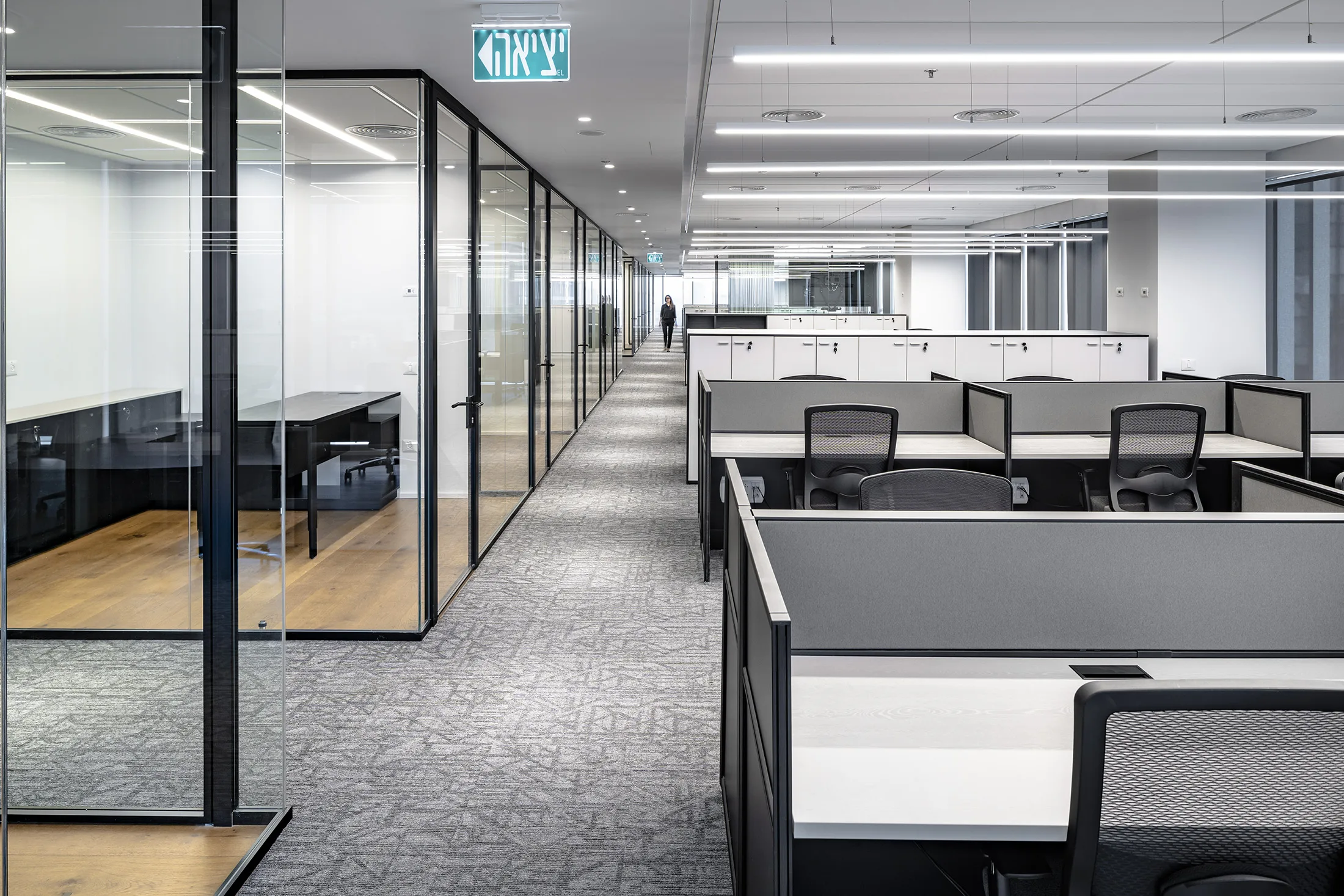A glazed corridor beside the open-plan workspace
