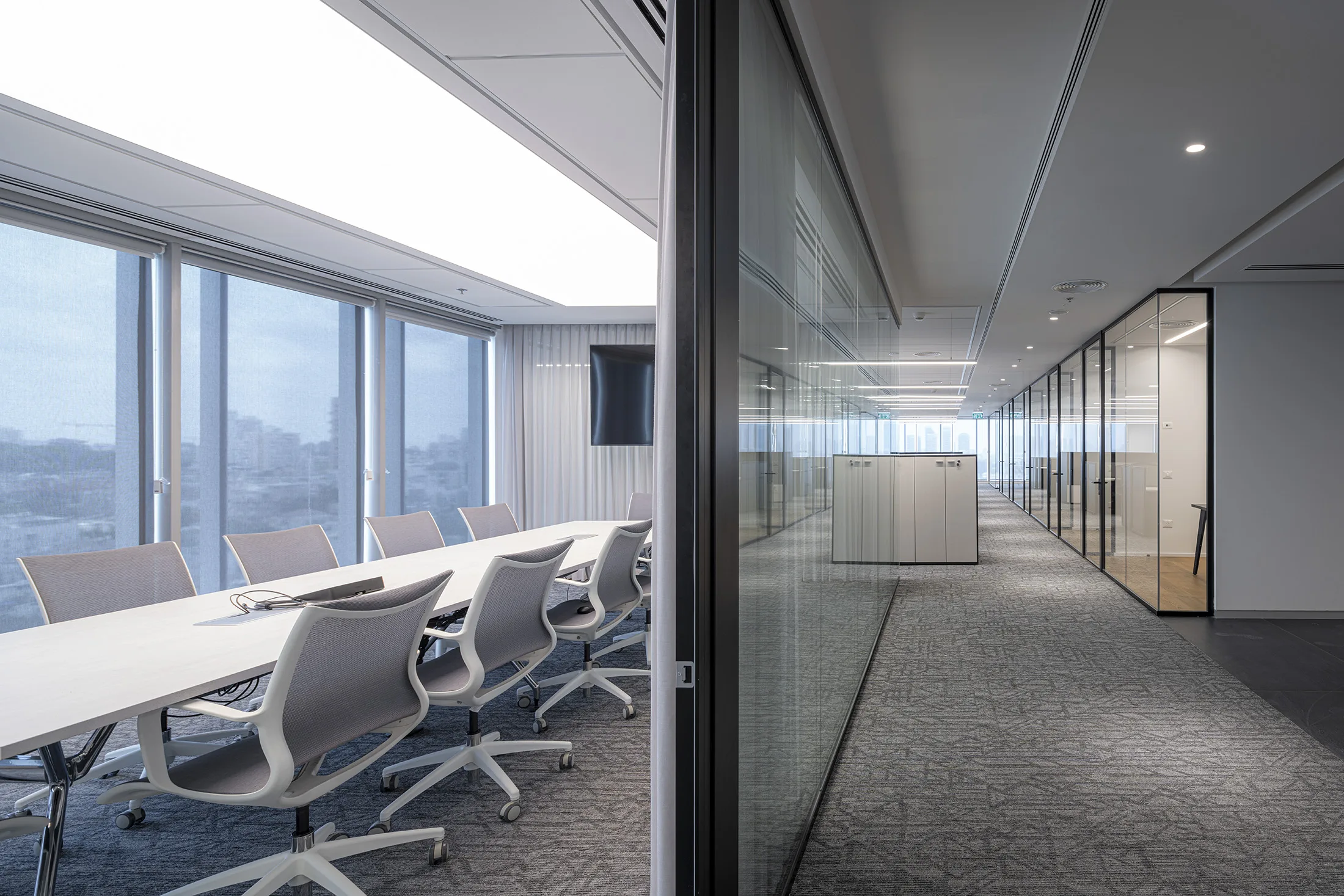 A view from the boardroom toward a corridor lit by a continuous light line