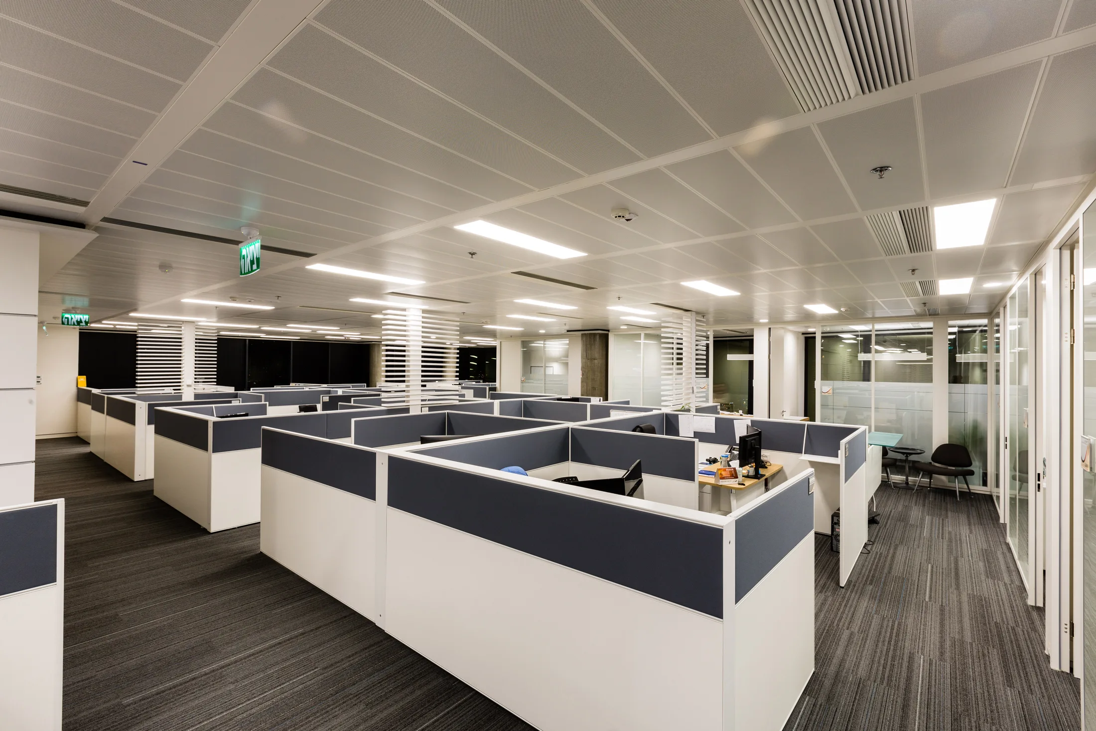 A typical open office floor under linear and panel lighting
