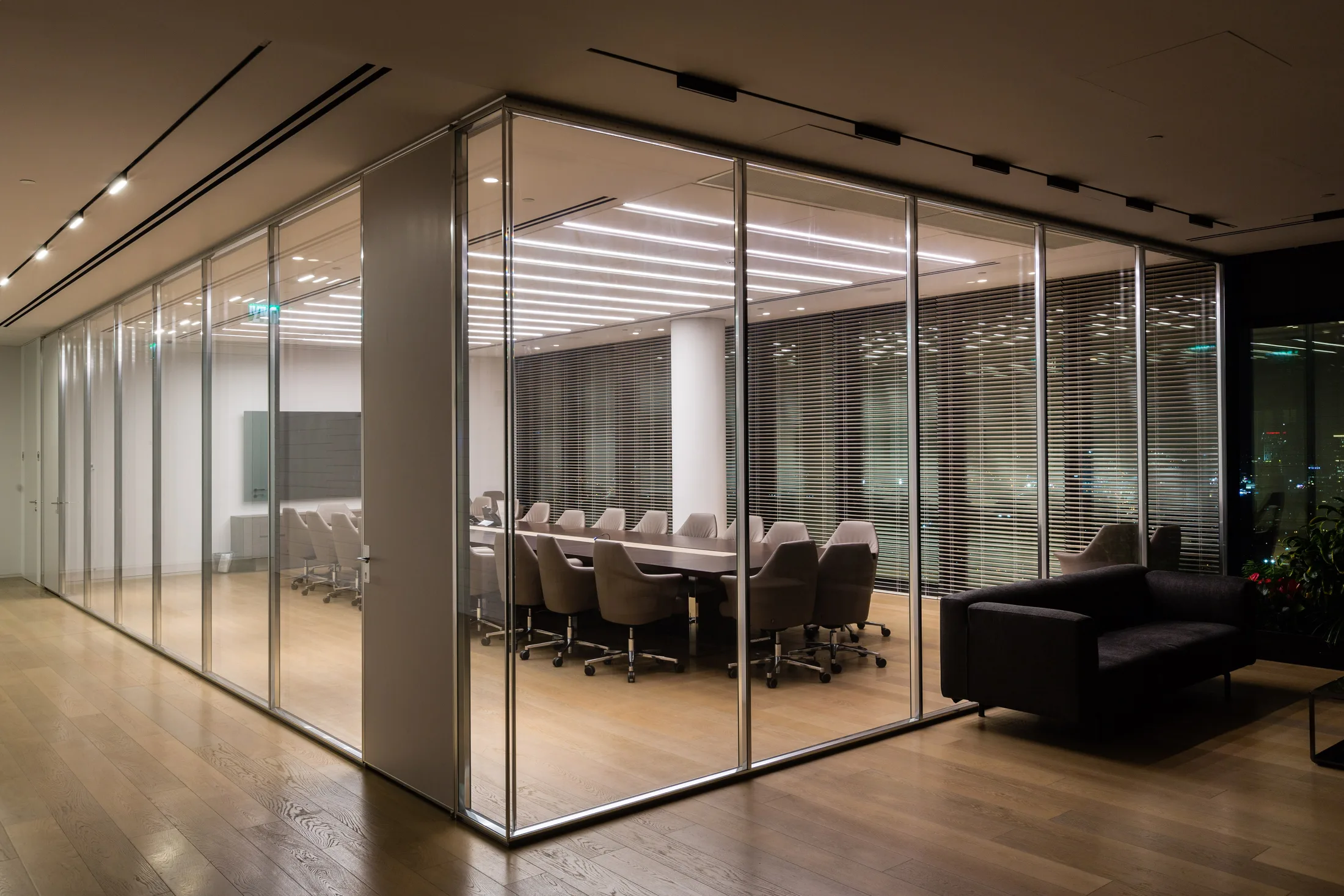 A glazed boardroom with an illuminated ceiling raft