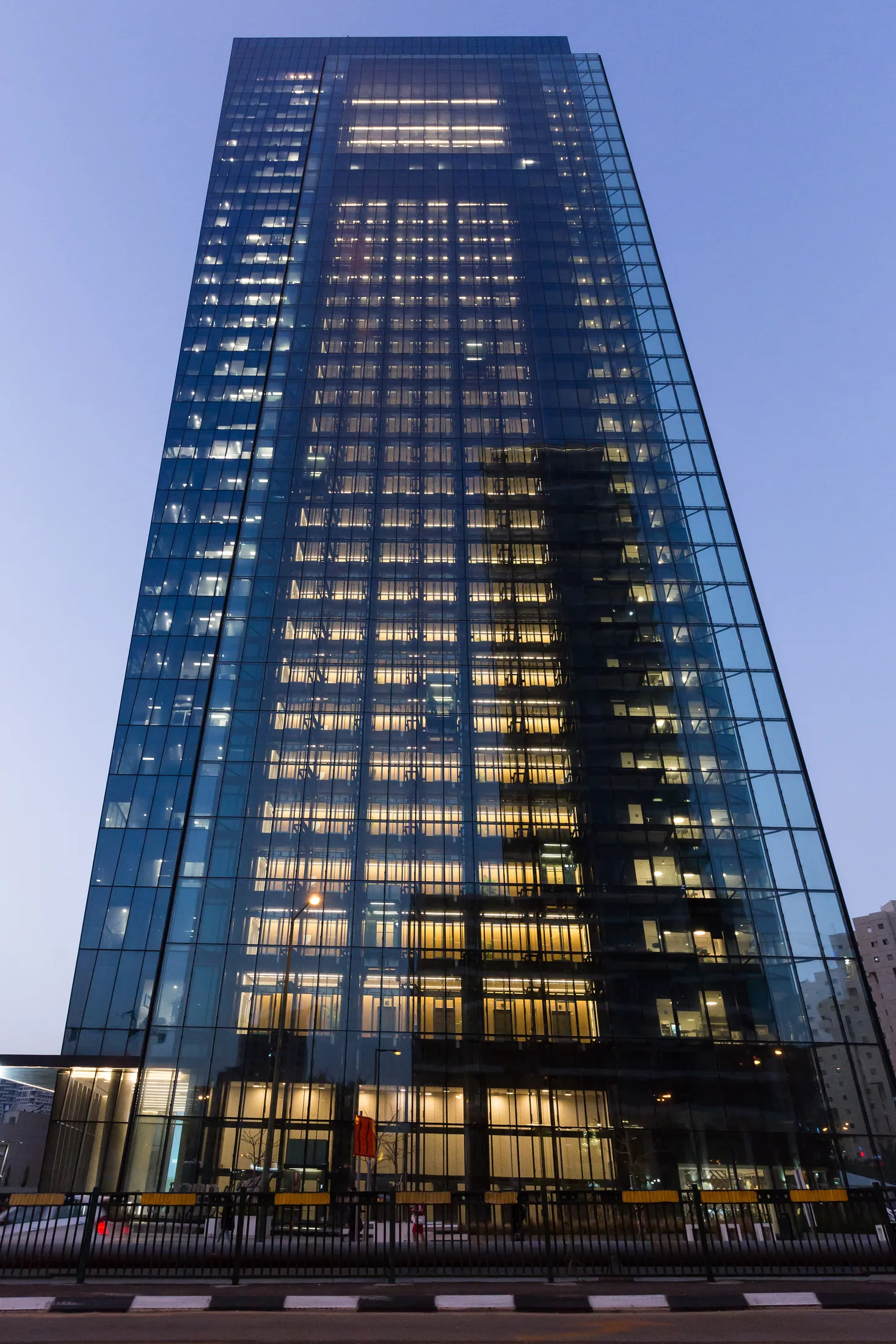 The Menora Mivtachim Tower facade lit at dusk