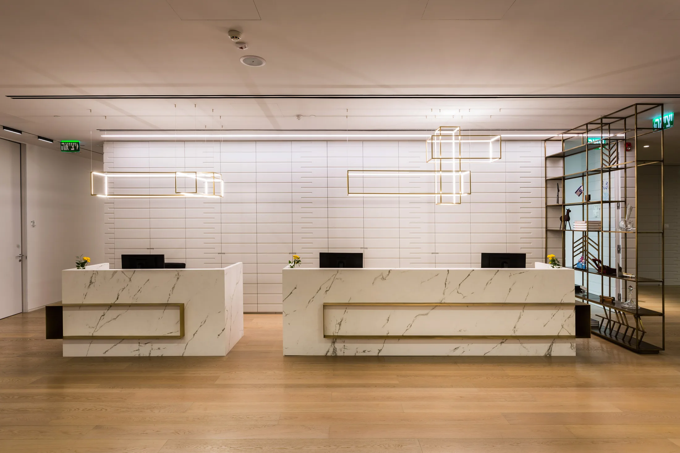 Marble reception desks under geometric brass light fittings