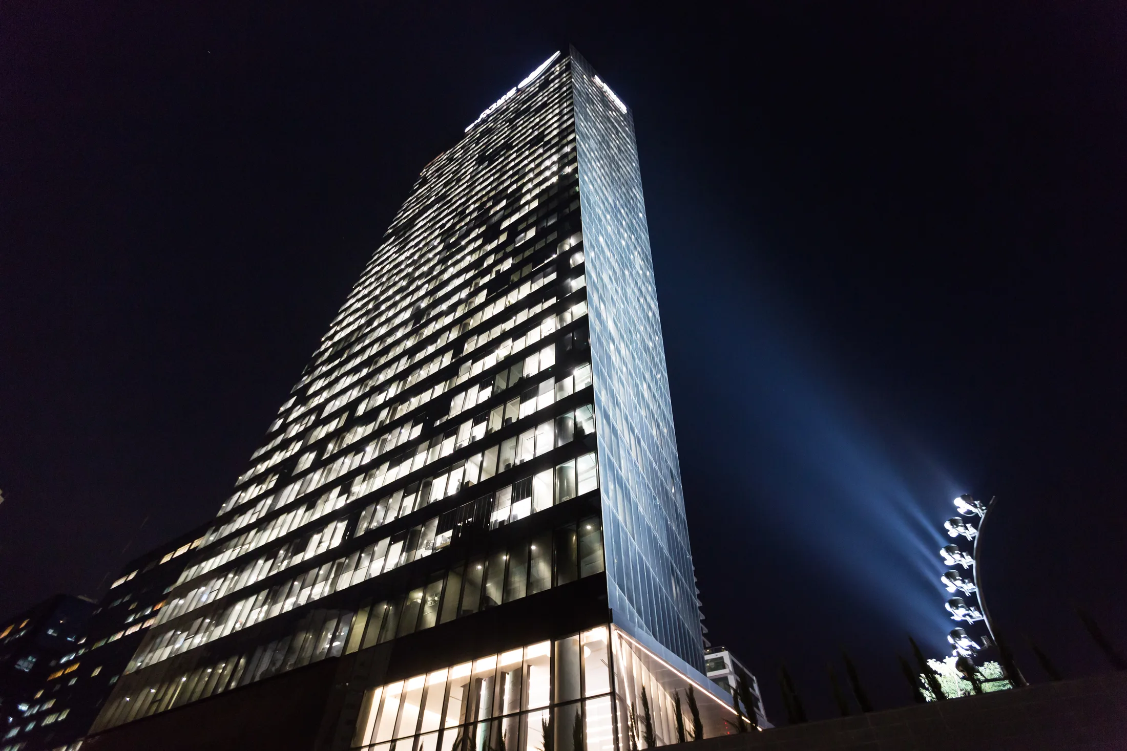 The full tower and illuminated lobby base at night