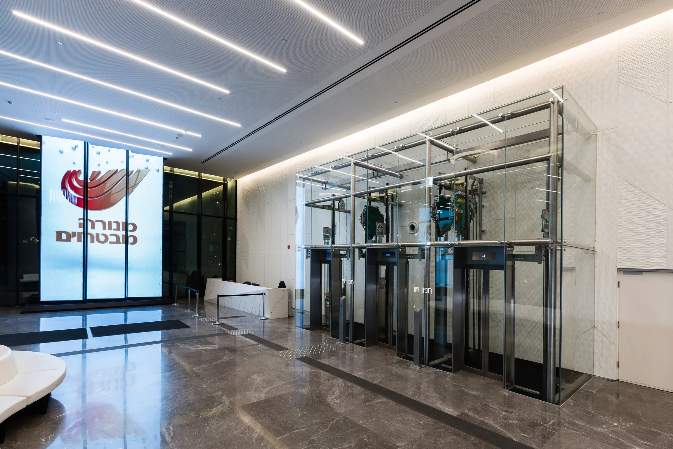 The main lobby with the Menora Mivtachim logo wall and turnstiles