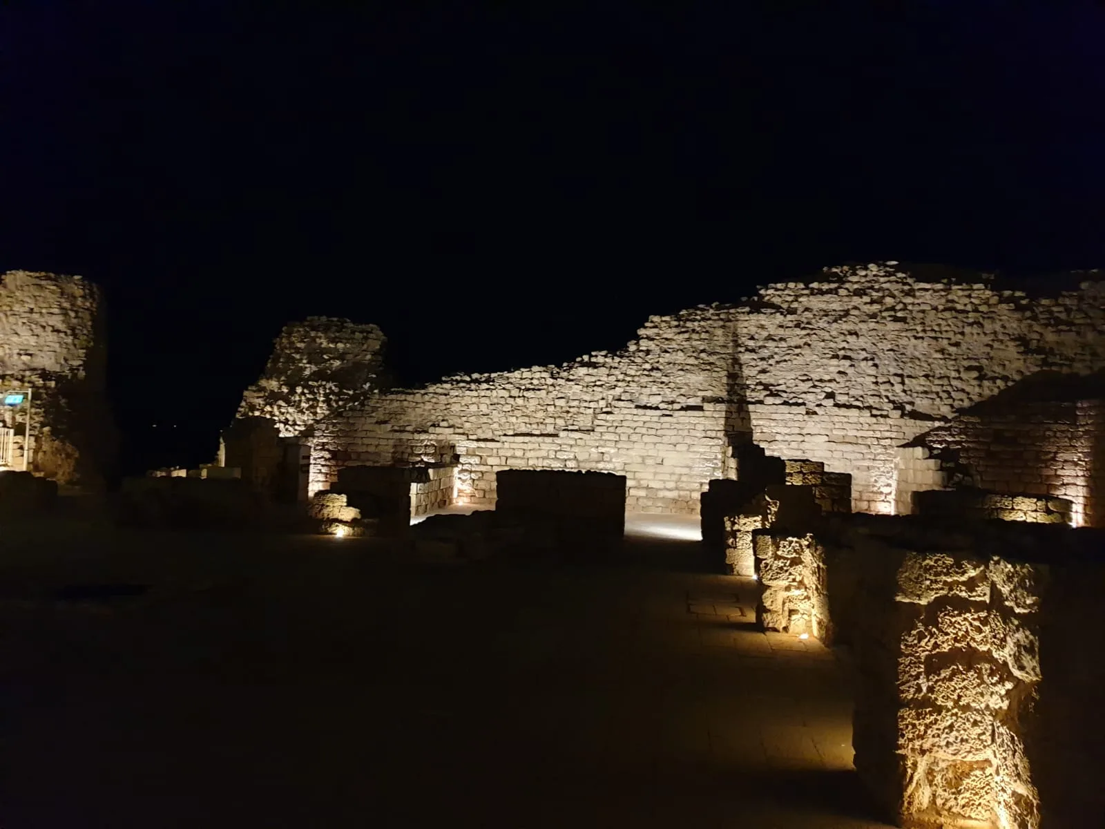 Illuminated fortress walls and ruins at night