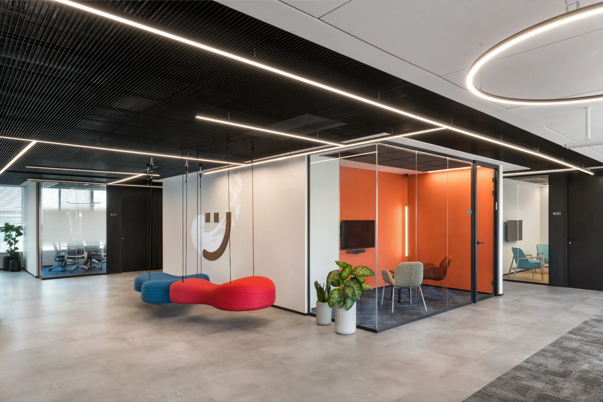 Collaboration area with swing seats and an orange meeting pod