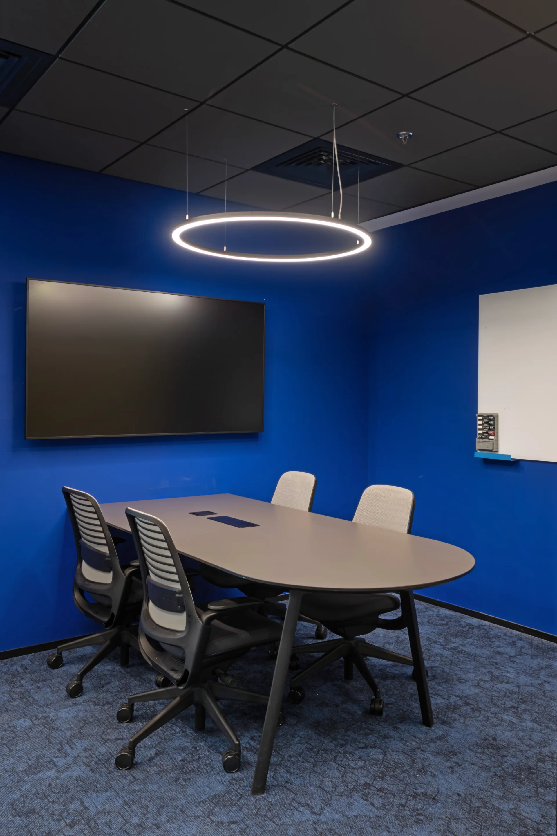 Blue meeting room with a suspended light ring