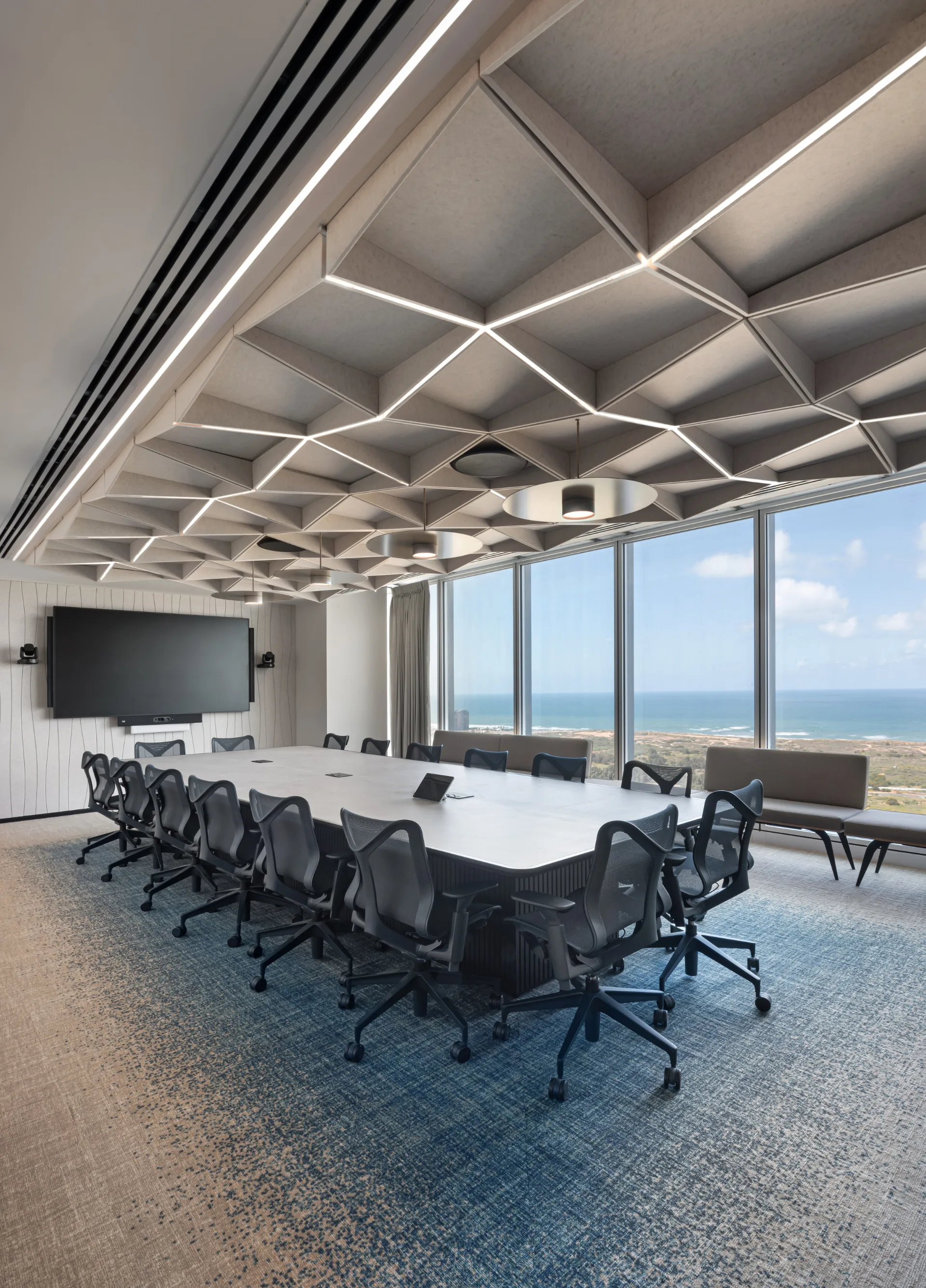 Felt ceiling with light seams and disc fixtures in a meeting room