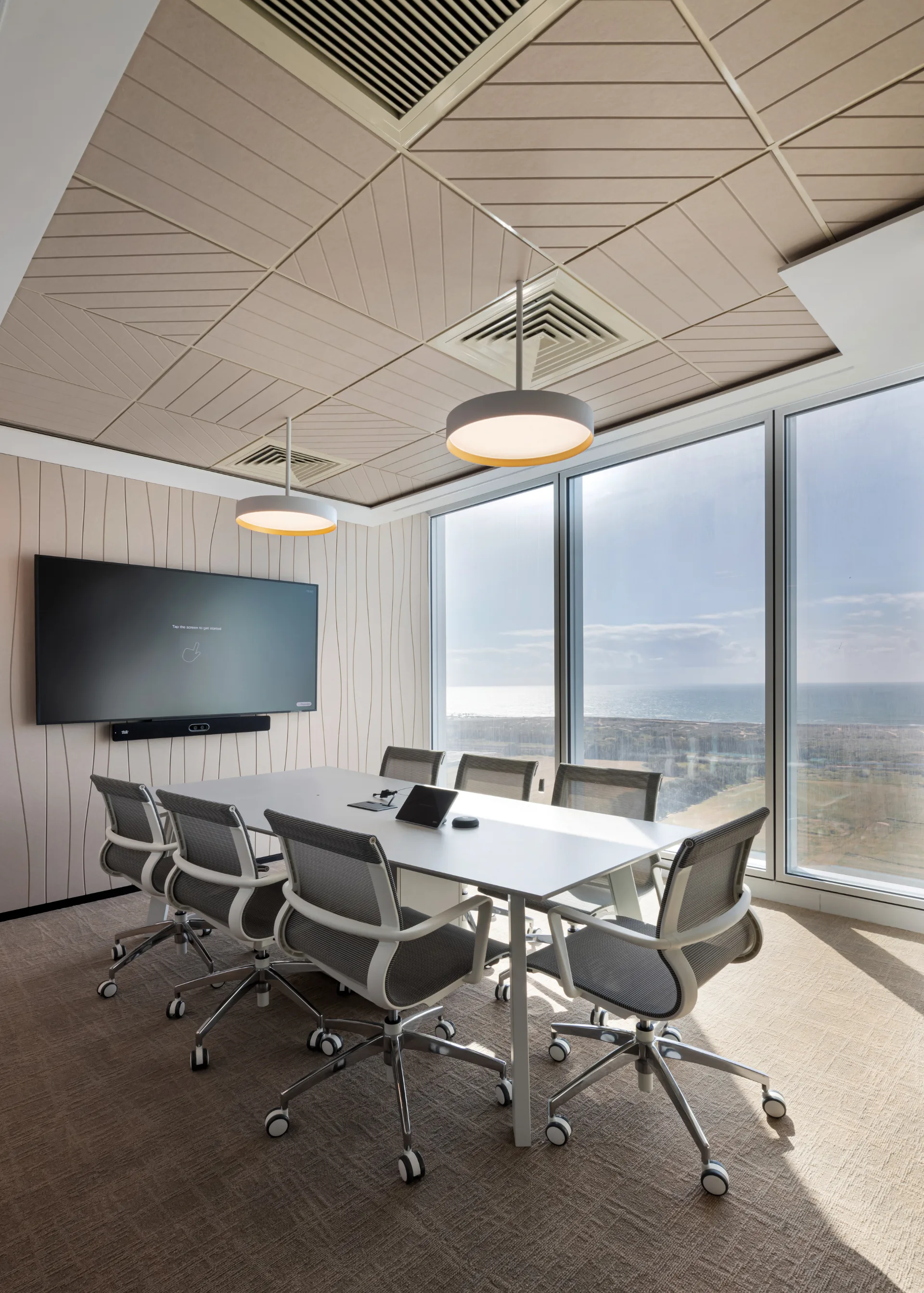 Small meeting room with disc fixtures and a wave-lined felt wall