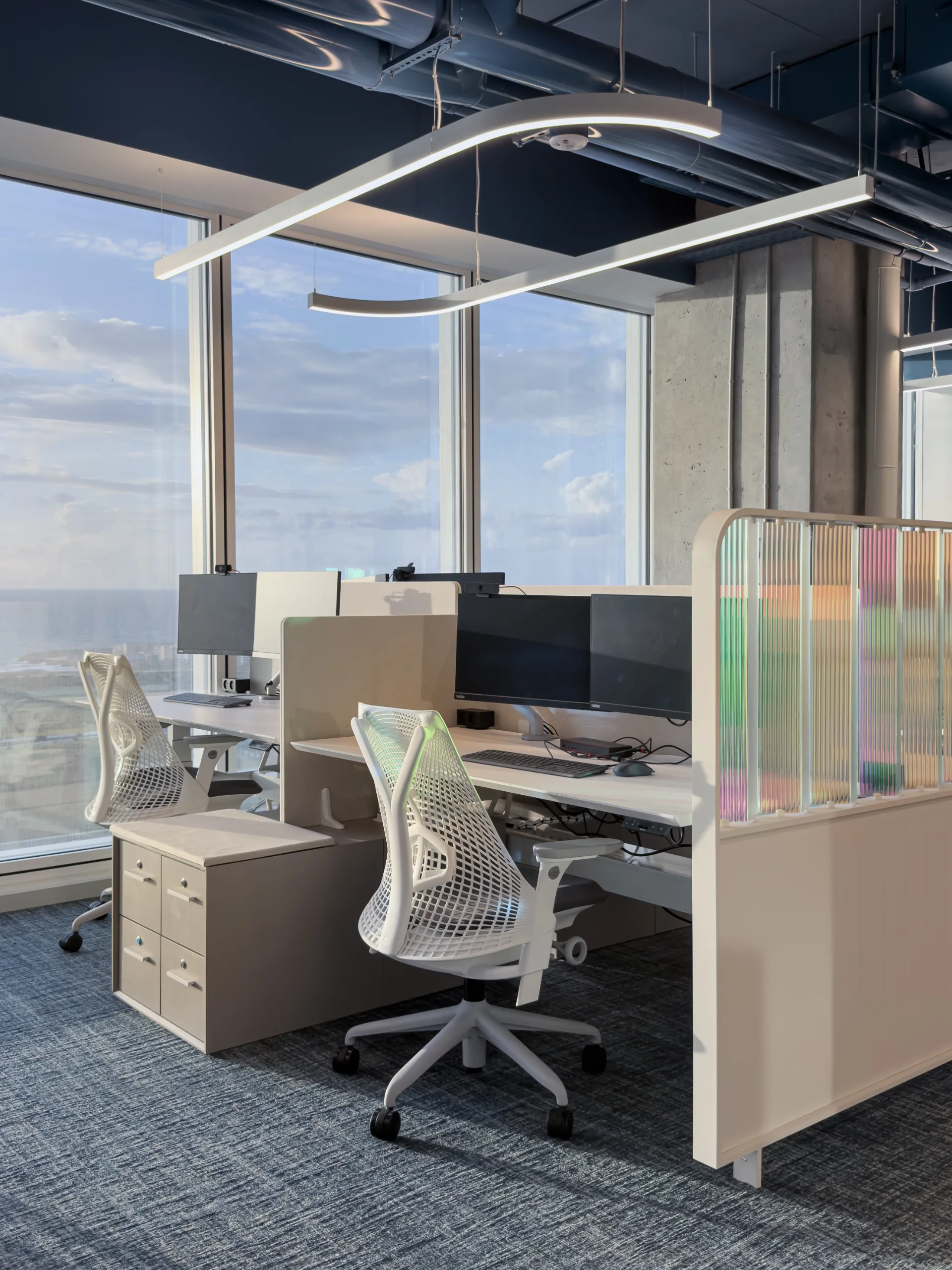 Workstations with iridescent screens and a wave linear fixture