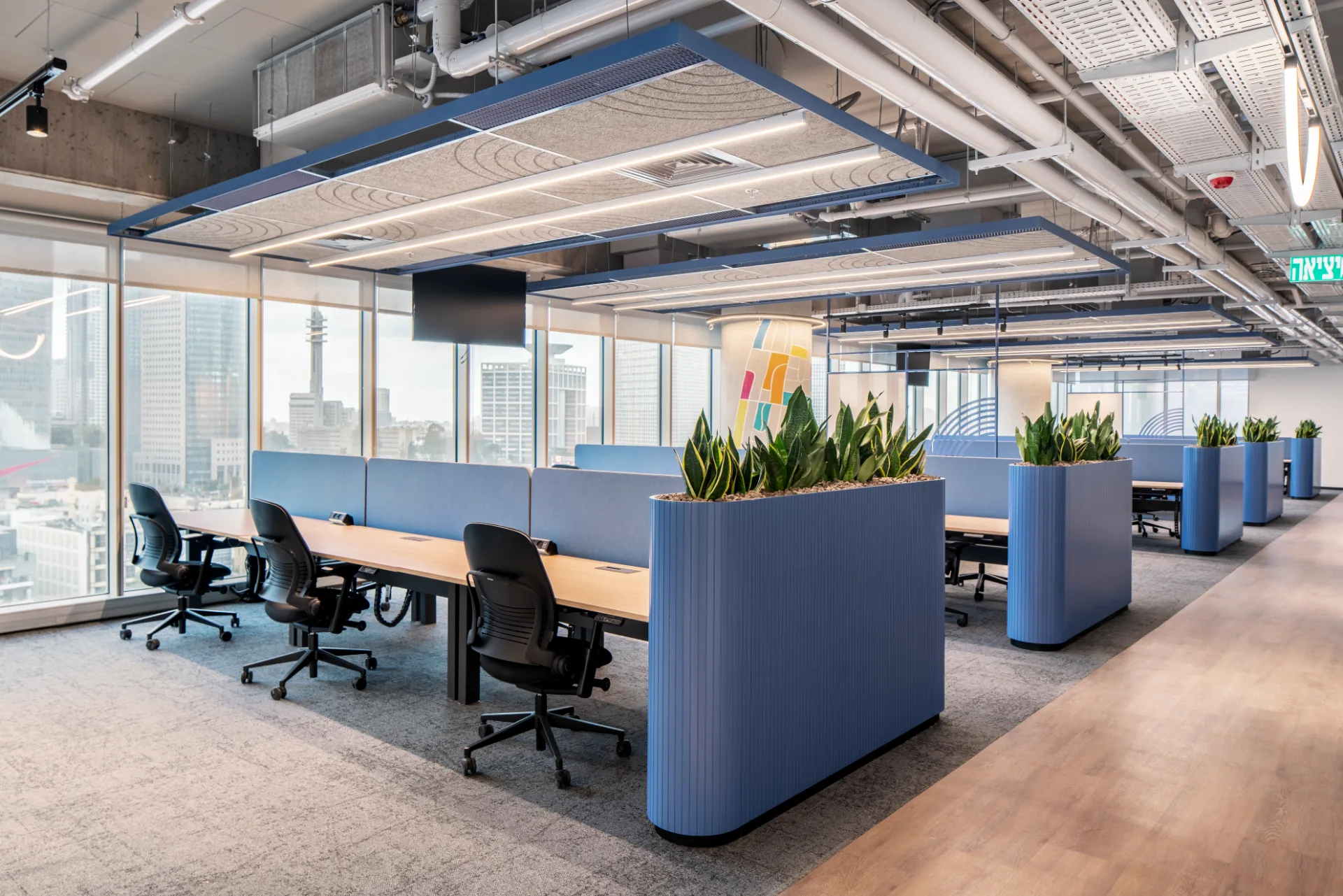 Open workspace with upholstered dividers and planting
