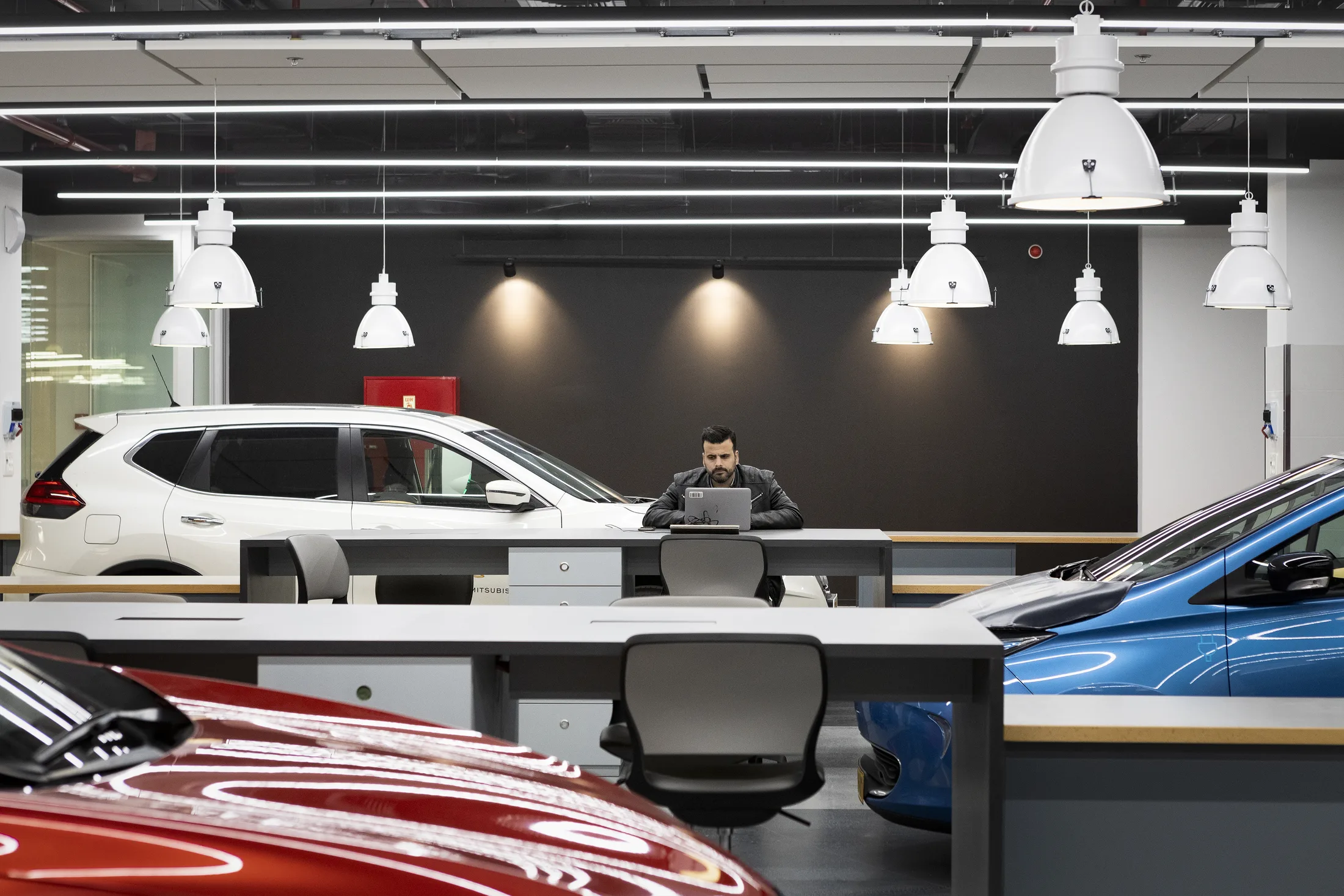 Test cars around a workbench under a row of dome pendants