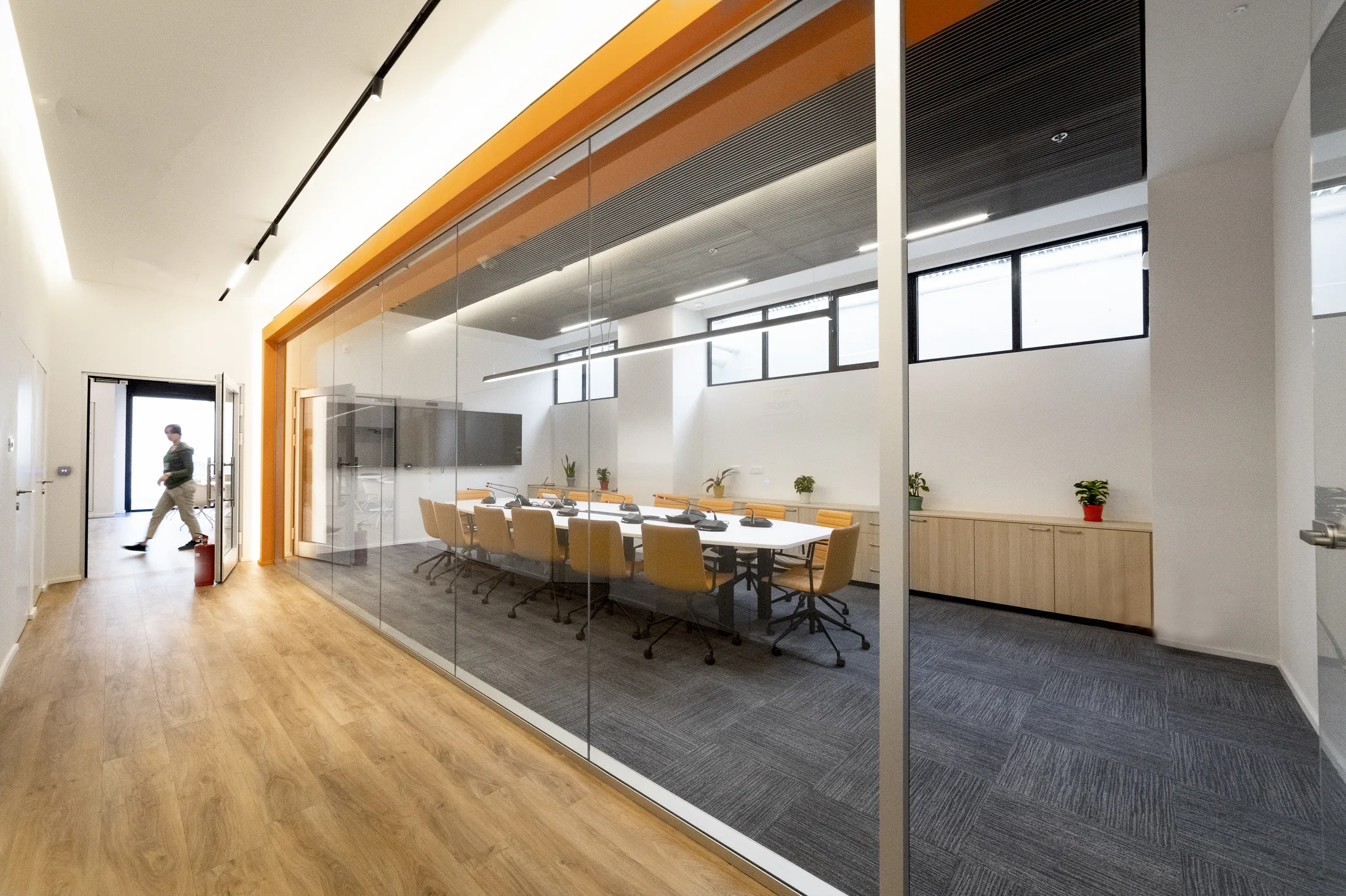 A glazed meeting room with an orange accent frame